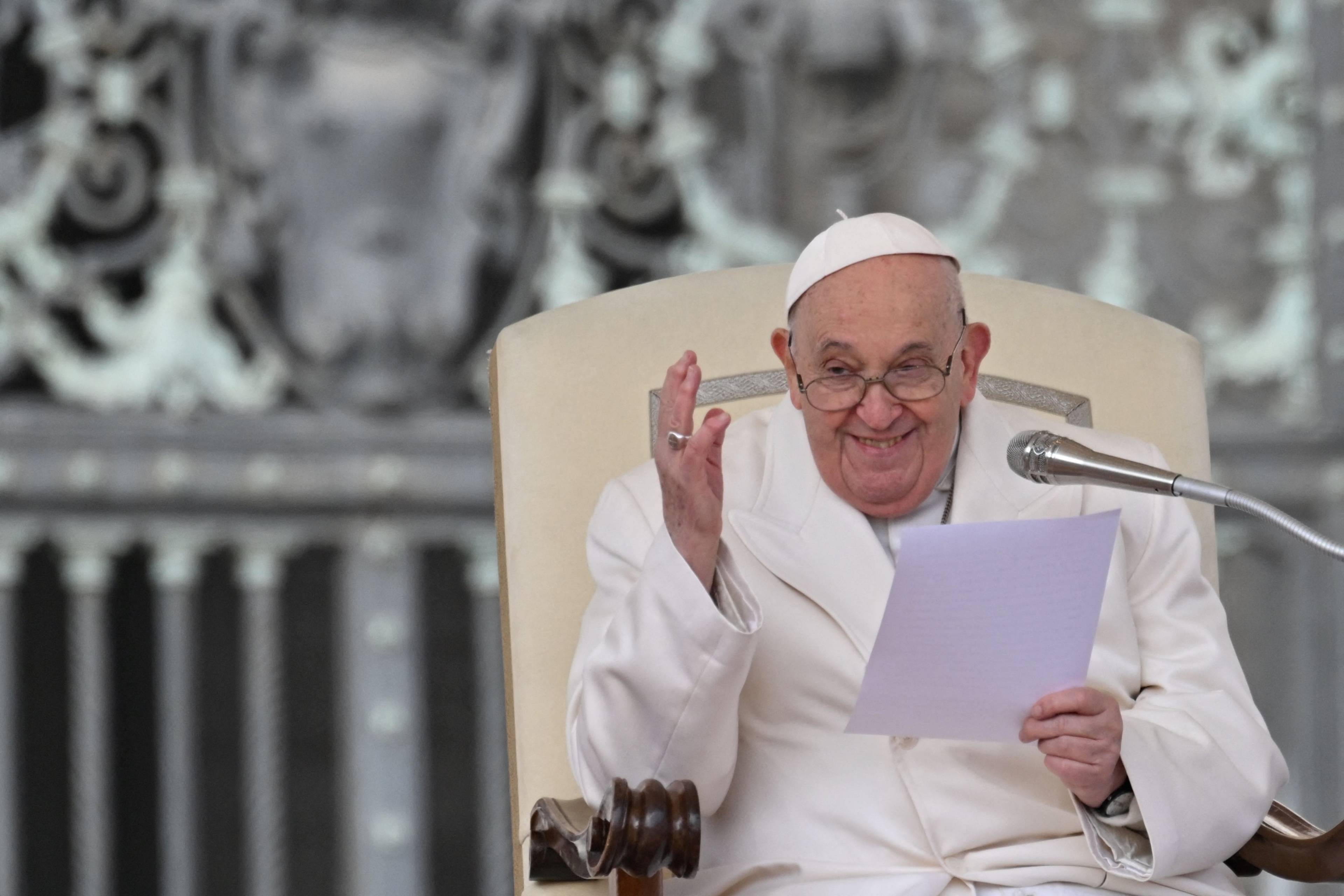Papież Franciszek przemawia podczas audiencji, siedząc na fotelu i trzymając w rękach kartkę