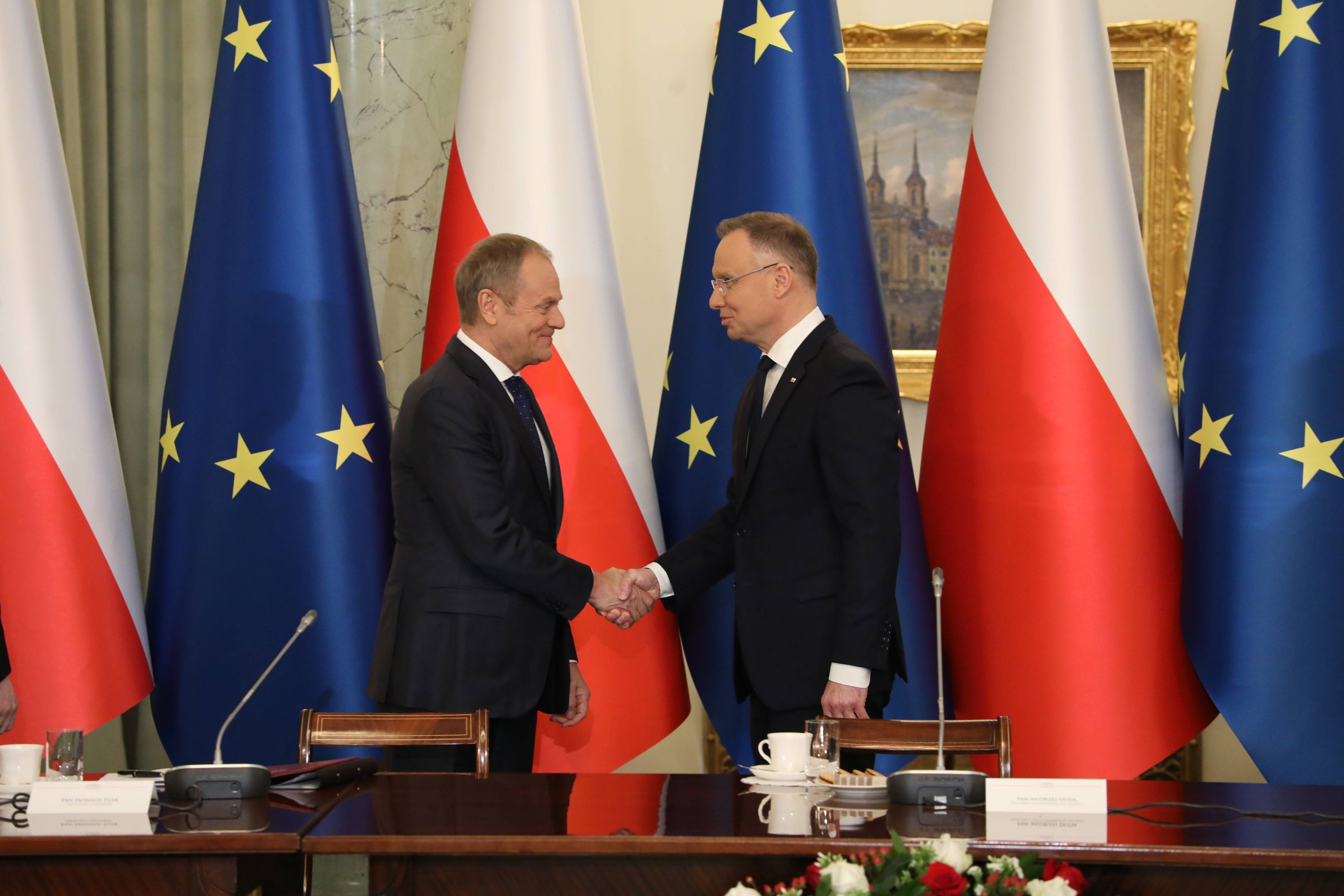 Donald Tusk i Andrzej Duda ściskają sobie dłonie