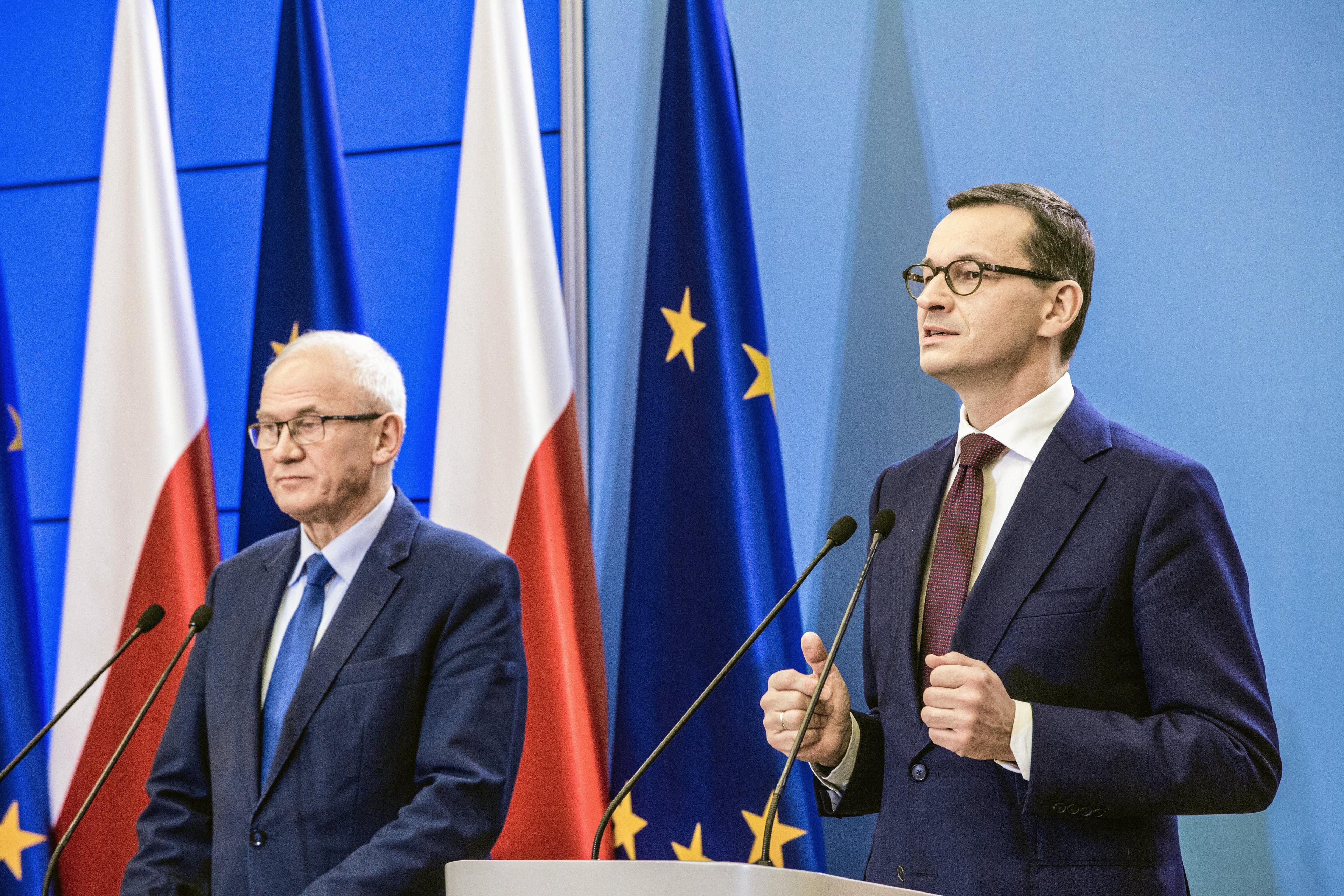 Minister Tchórzewski obok gestykulującego premiera Morawieckiego podczas konferencji prasowej w grudniu 2018
