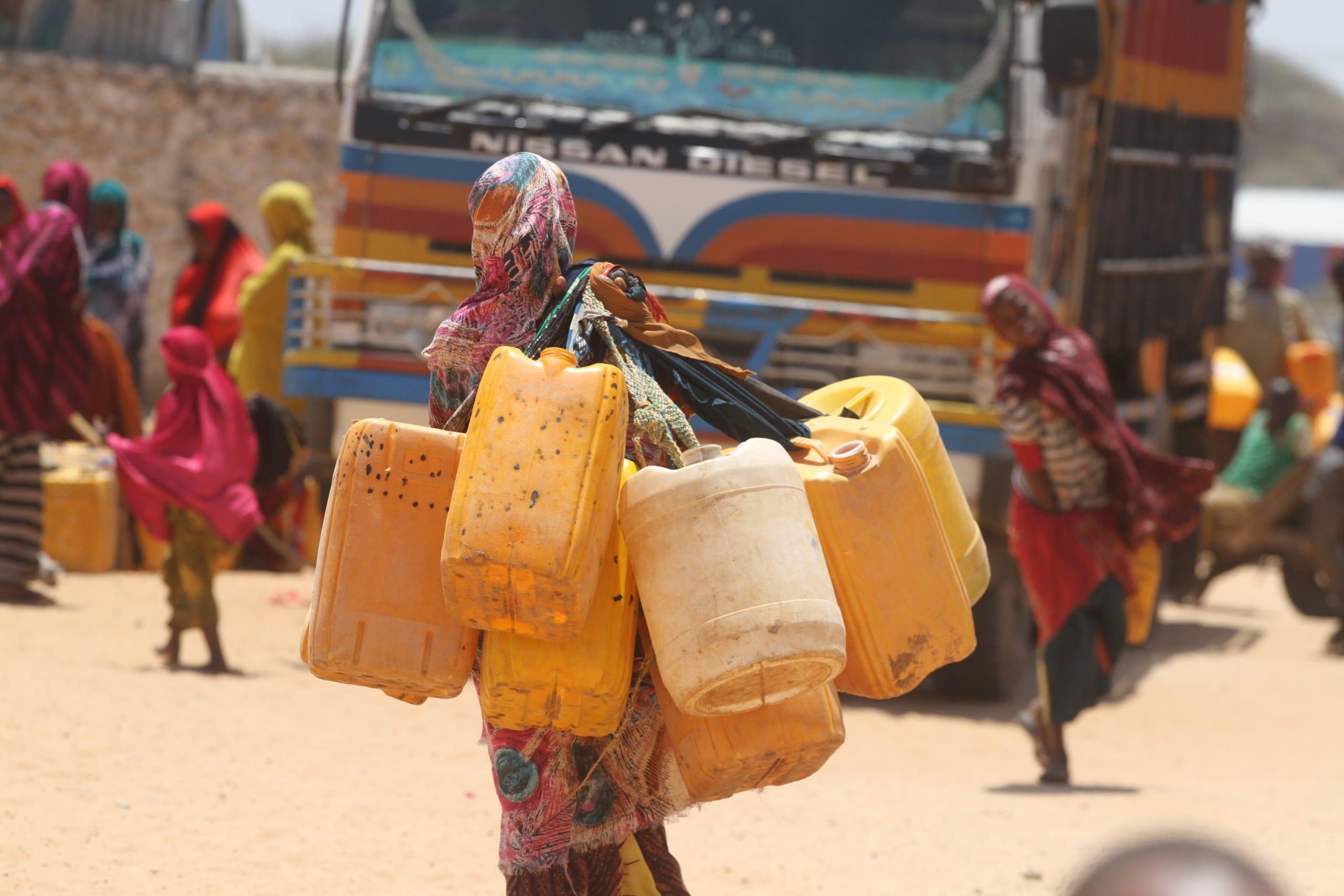 Somalia, kobieta niesie baniaki z wodą