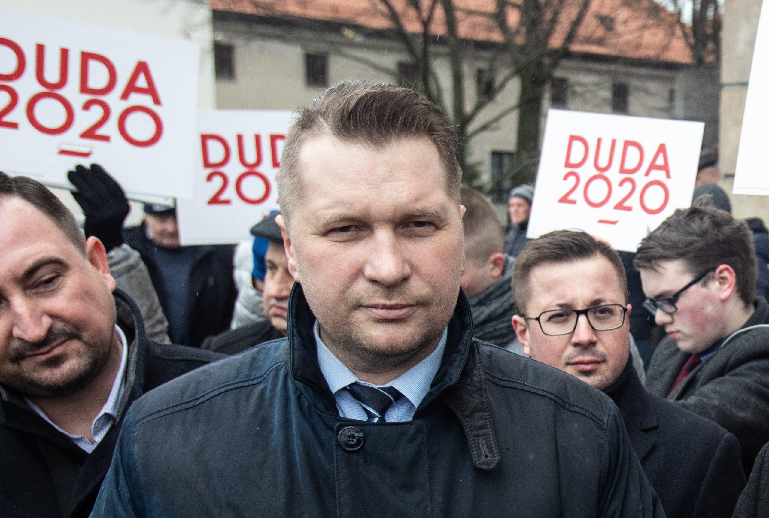 Przemysław Czarnek, za nim bannery z napisem "Duda 2020"