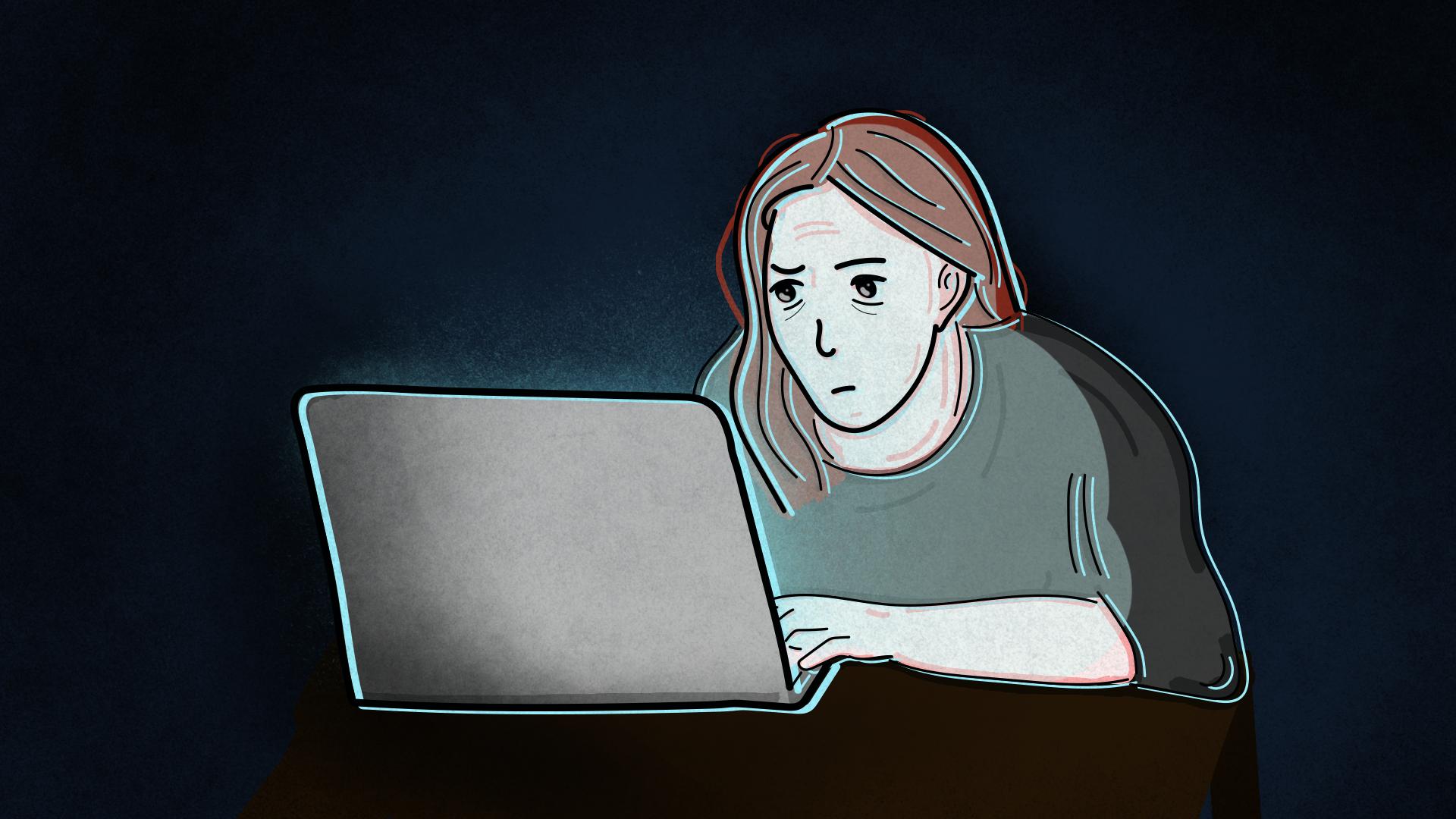 Postać smutnej kobiety siedzącej przed laptopem