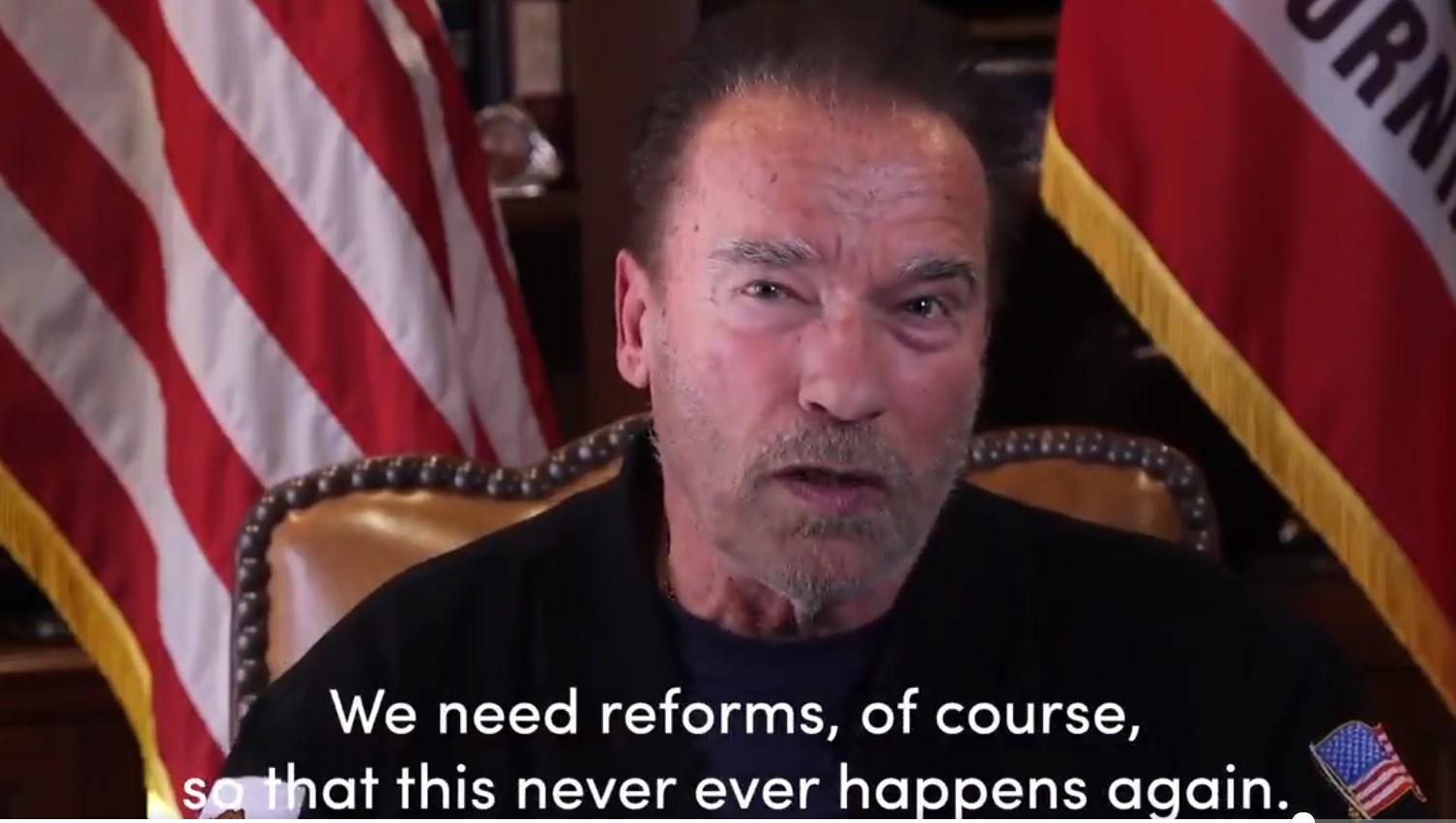 Arnold Schwarzenegger przemawia na tle flagi USA