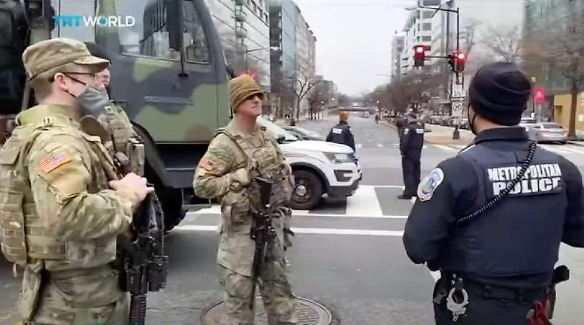 Waszyngton - Żołnierze w pełnym uzbrojeniu i zielonych mundfurach, oraz policjanci w czarnych mundurach na skrzyżowaniu ulic