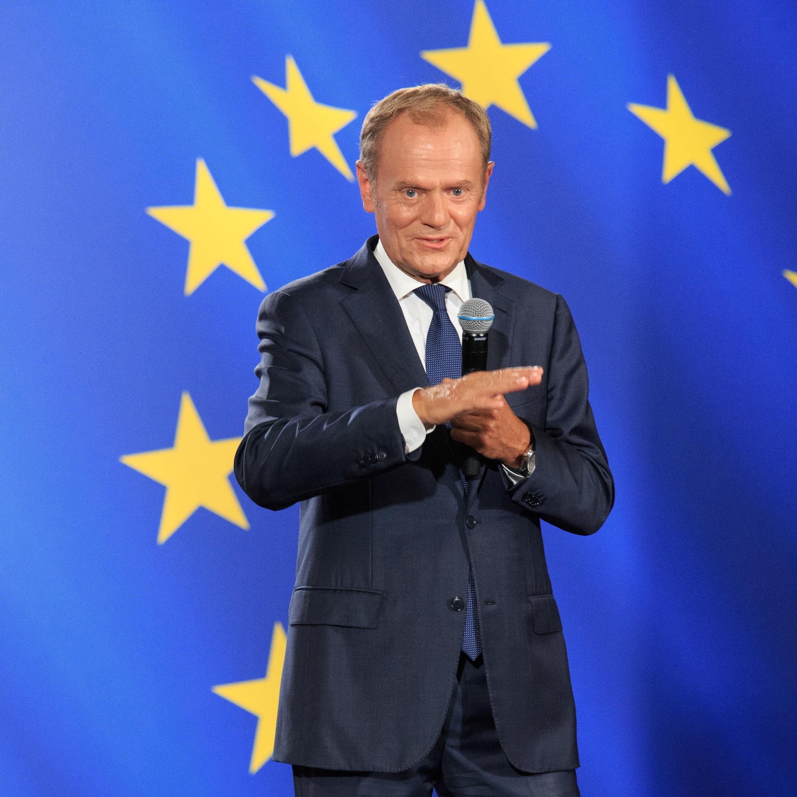 Donald Tusk na tle unijnej flagi