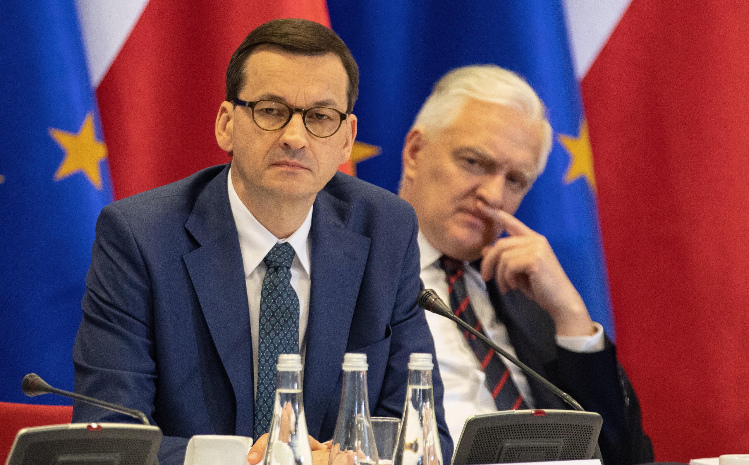 Mateusz Morawiecki i Jarosław Gowin na tle flag Polski i UE