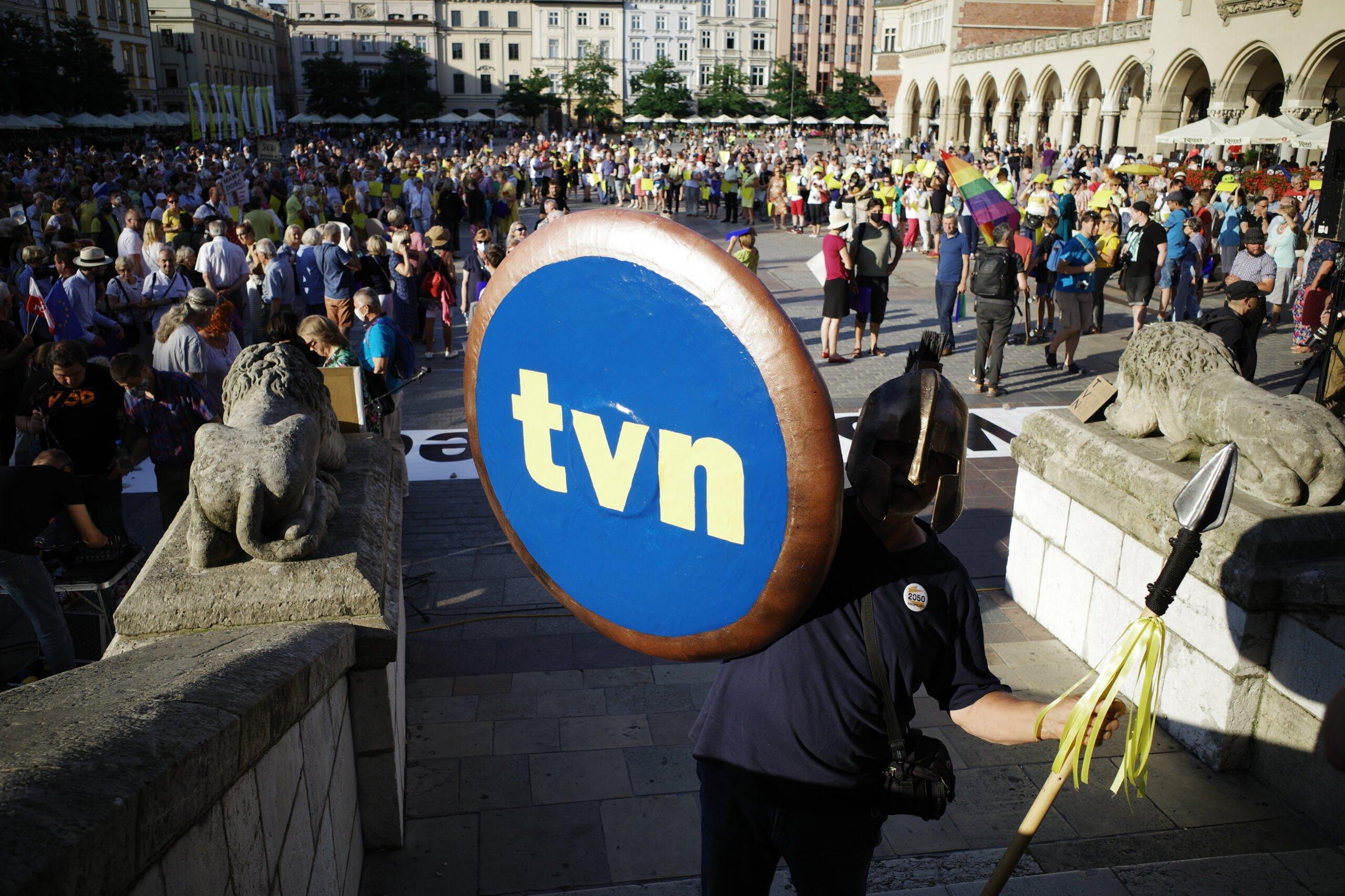 Niebieskie logo z napisem TVN na demonstracji, w tle - Sukiennice w Krakowie