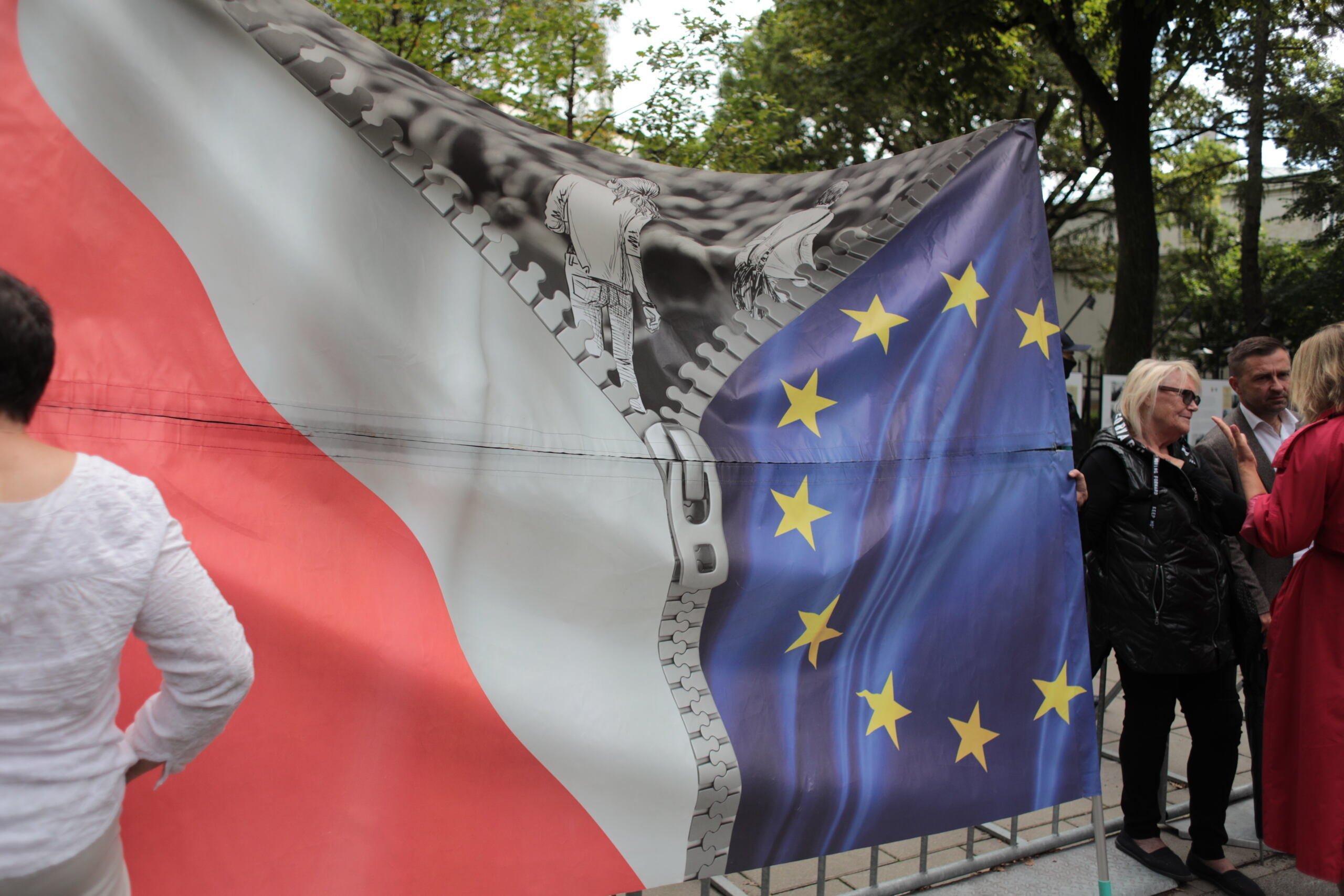 Transparent pokazujący rozszczepiające się flagi polską i unijną, protest przed TK w związku z rozpatrywaniem zapytania premiera Morawieckiego ws. orzeczeń TSUE