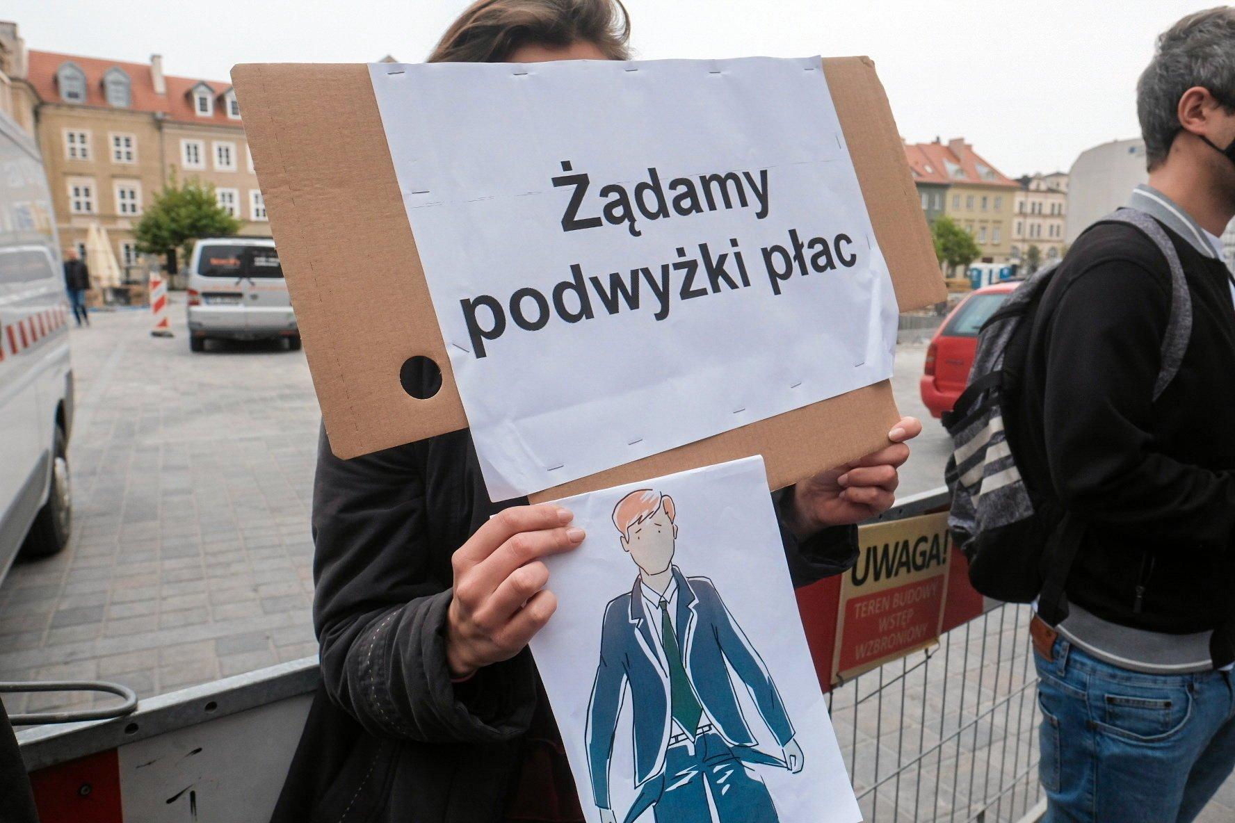 protest z transparentem "Żądamy podwyżki płac"