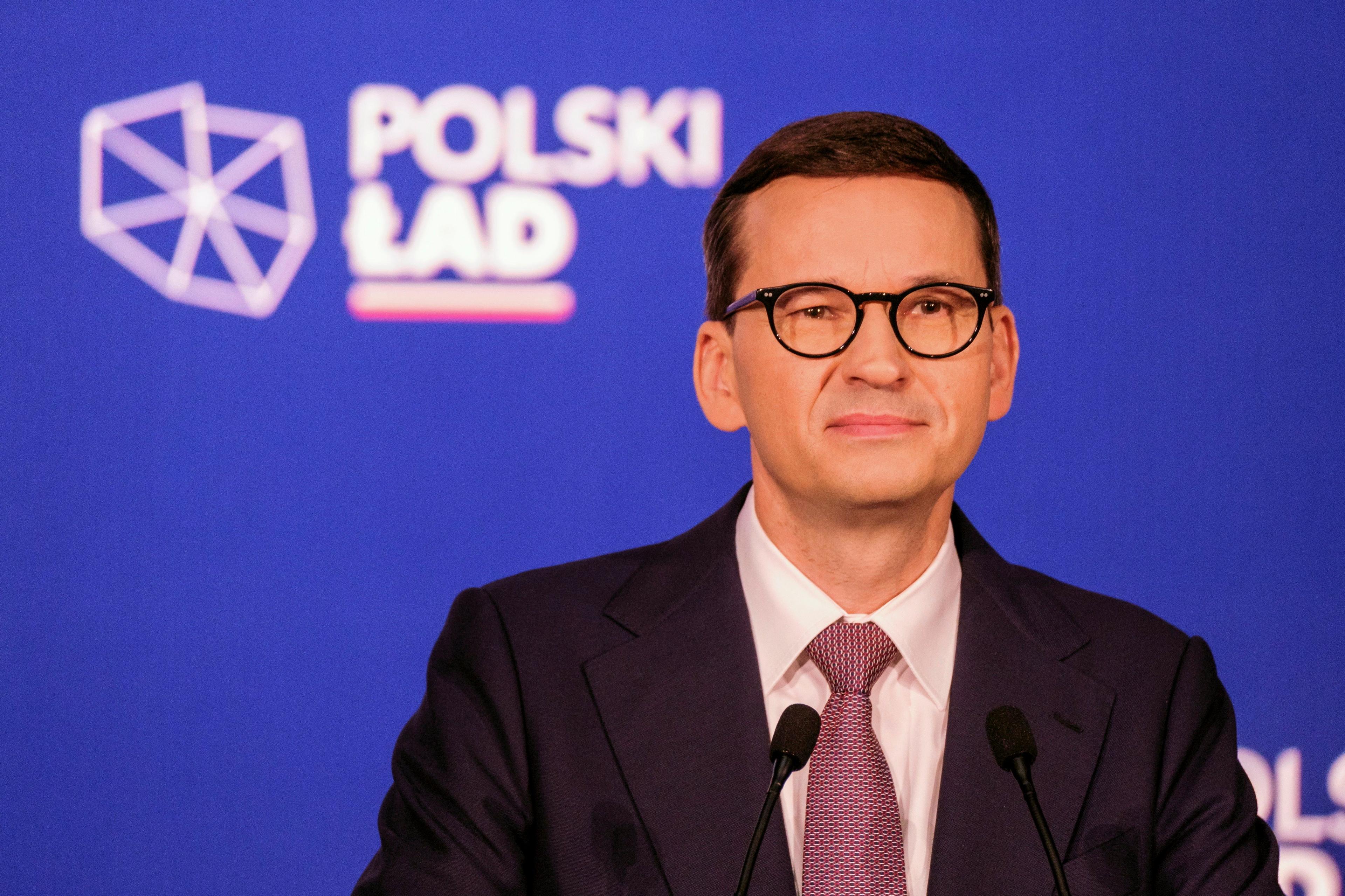 Mężczyzna w średnim wieku w garniturze. To premier Mateusz Morawiecki. W tle napis "Polski Ład"