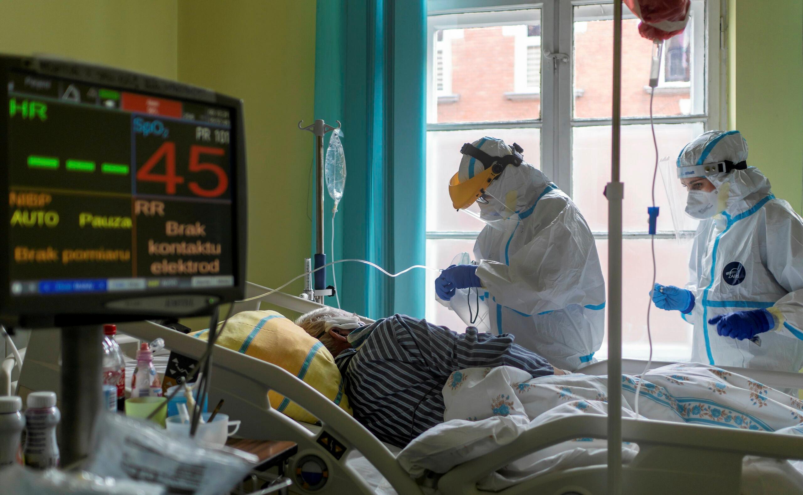 Personel w kombinezonach ochronnych zajmuje się chorym w oddziale covidowym Szpitala Miejskiego w Gliwicach