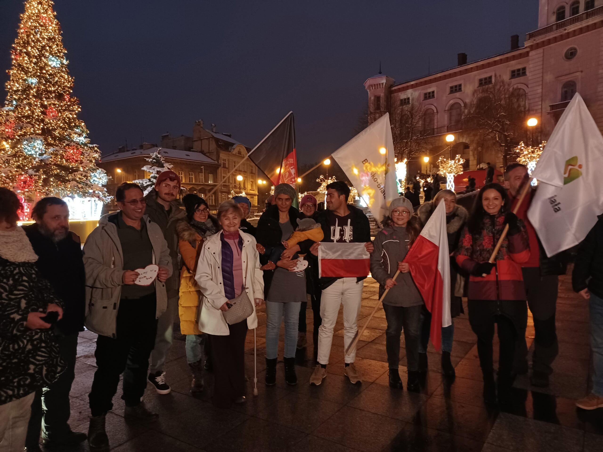 Ludzie z flagami Polski i Afganistanu na zabytkowym rynku