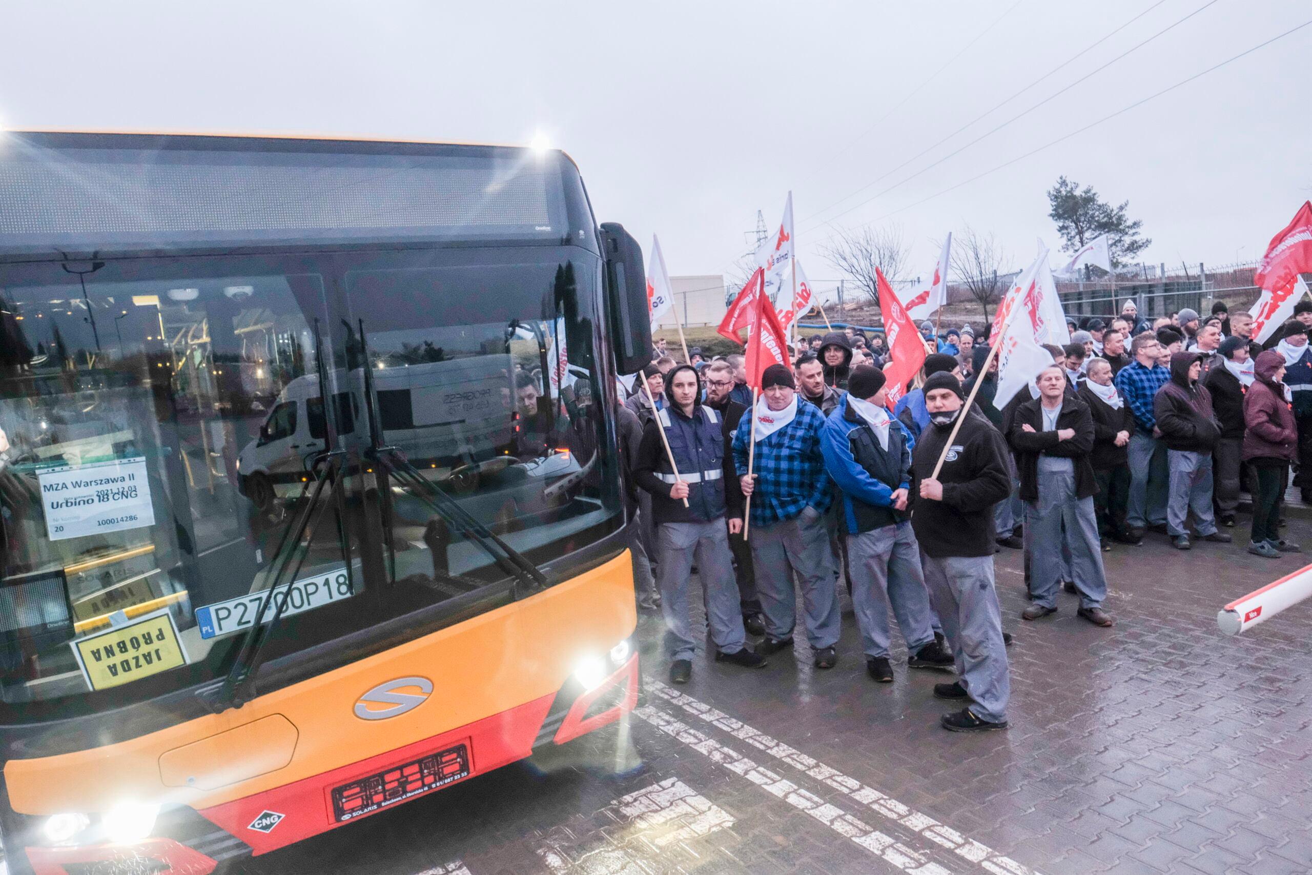 Autobus i tłum ludzi z flagami związkowymi