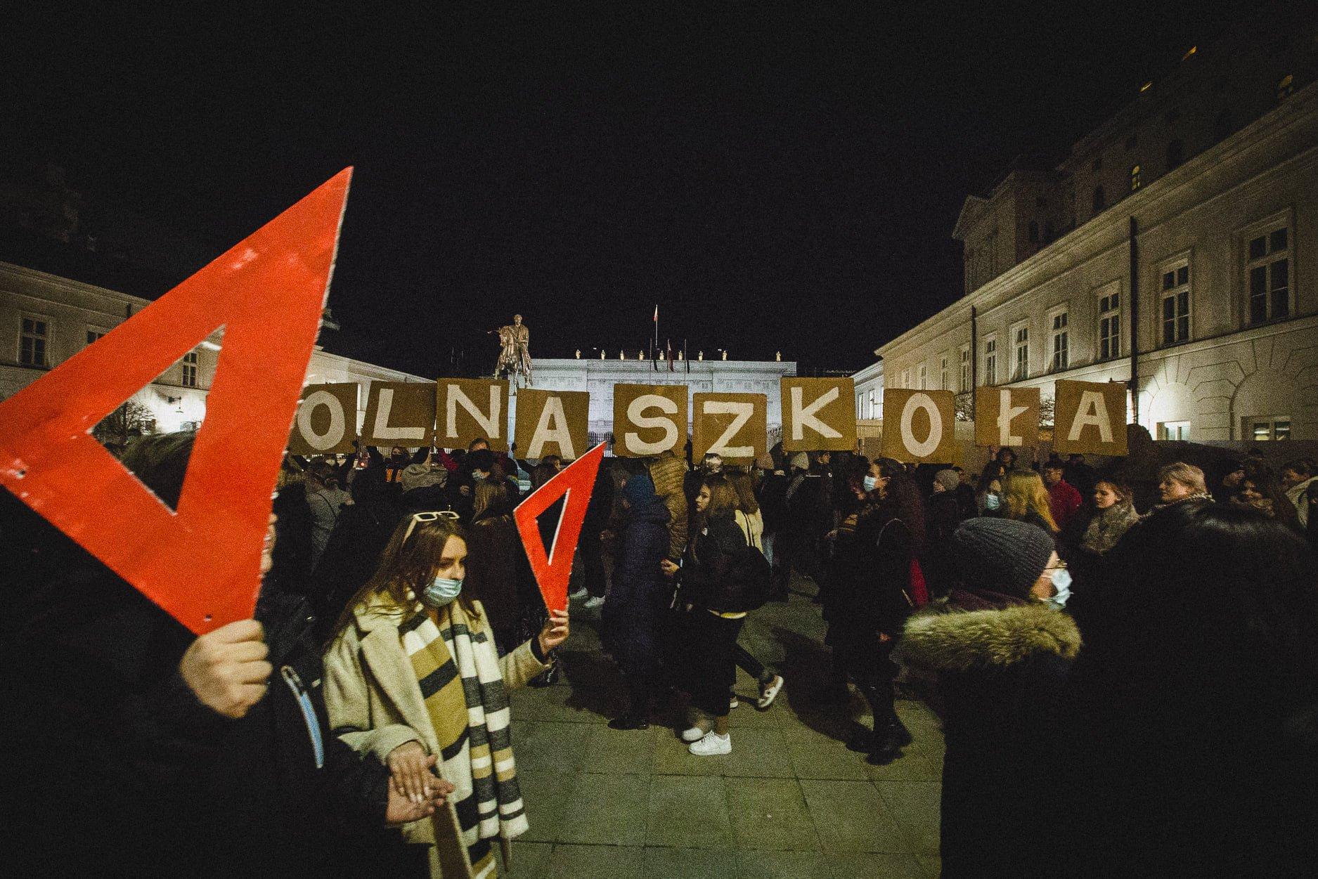 Protestująca młodzież z czerwonymi ekierkami i napisem „Wolna Szkoła" przed Pałacem Prezydenckim