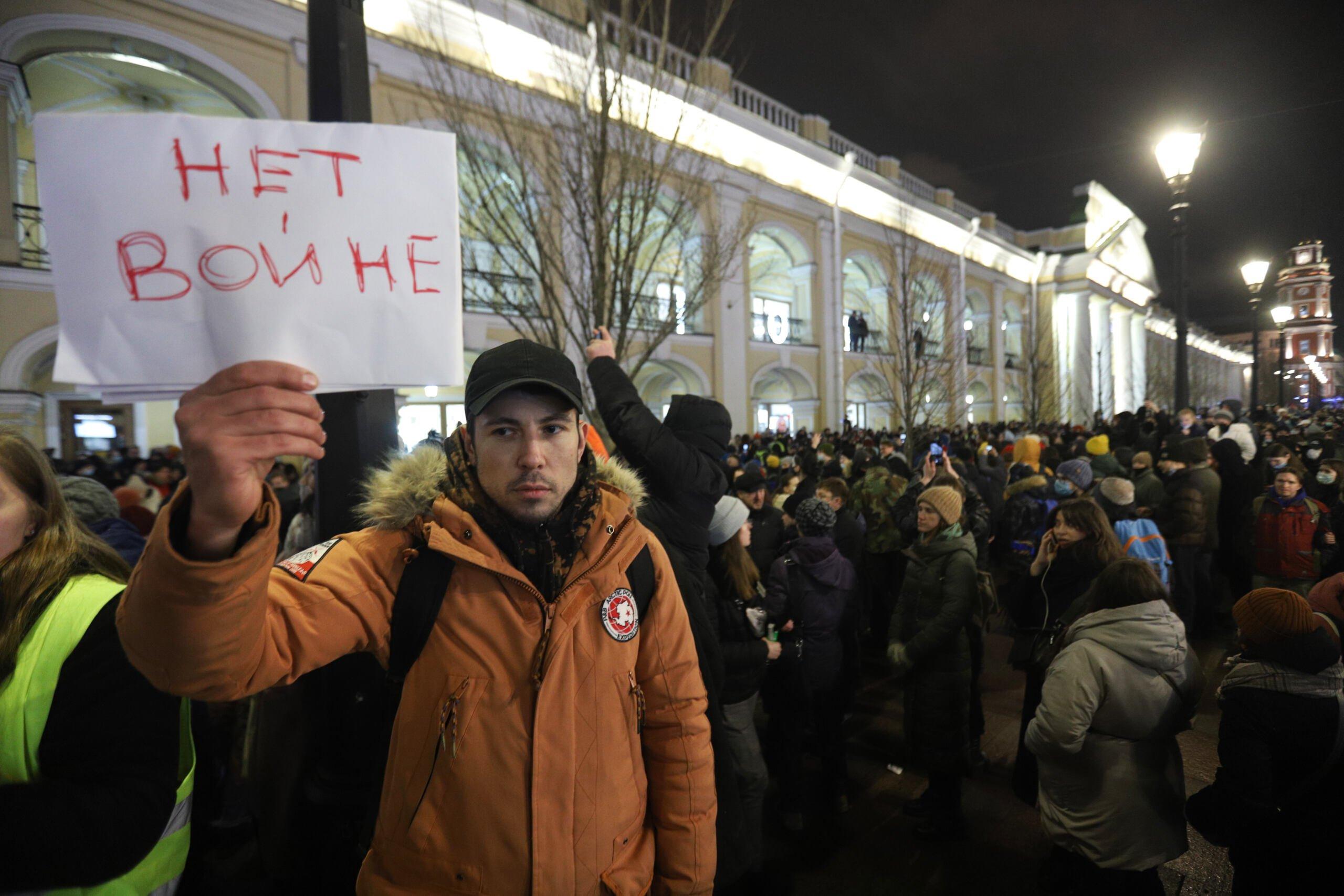 Młody człowiek trzyma napis po rosyjsku „niet wojnie"