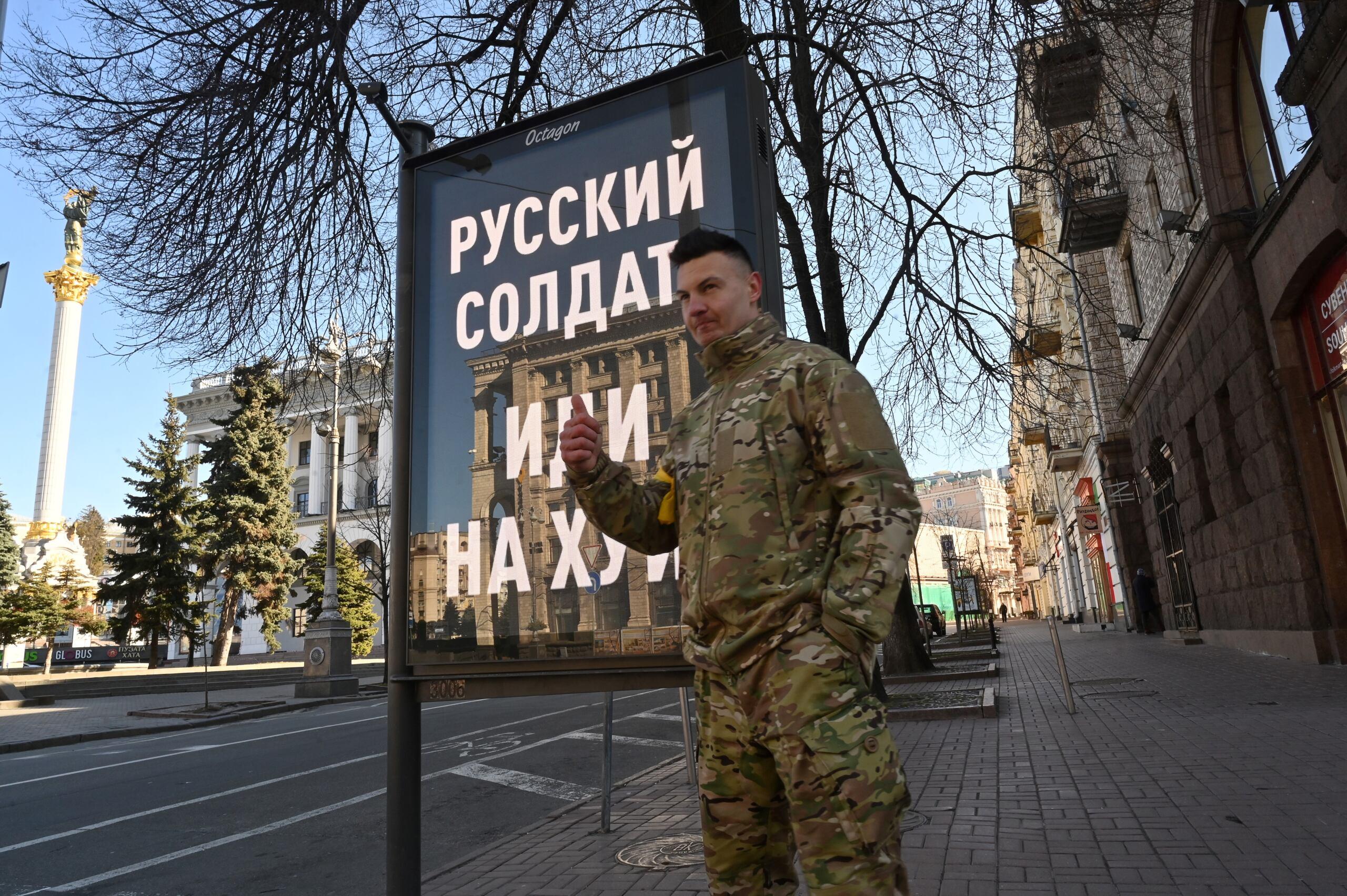 ukraiński żołnierz na Majdanie pozuje przy bilbordzie „russkij soldat idi na chuj"