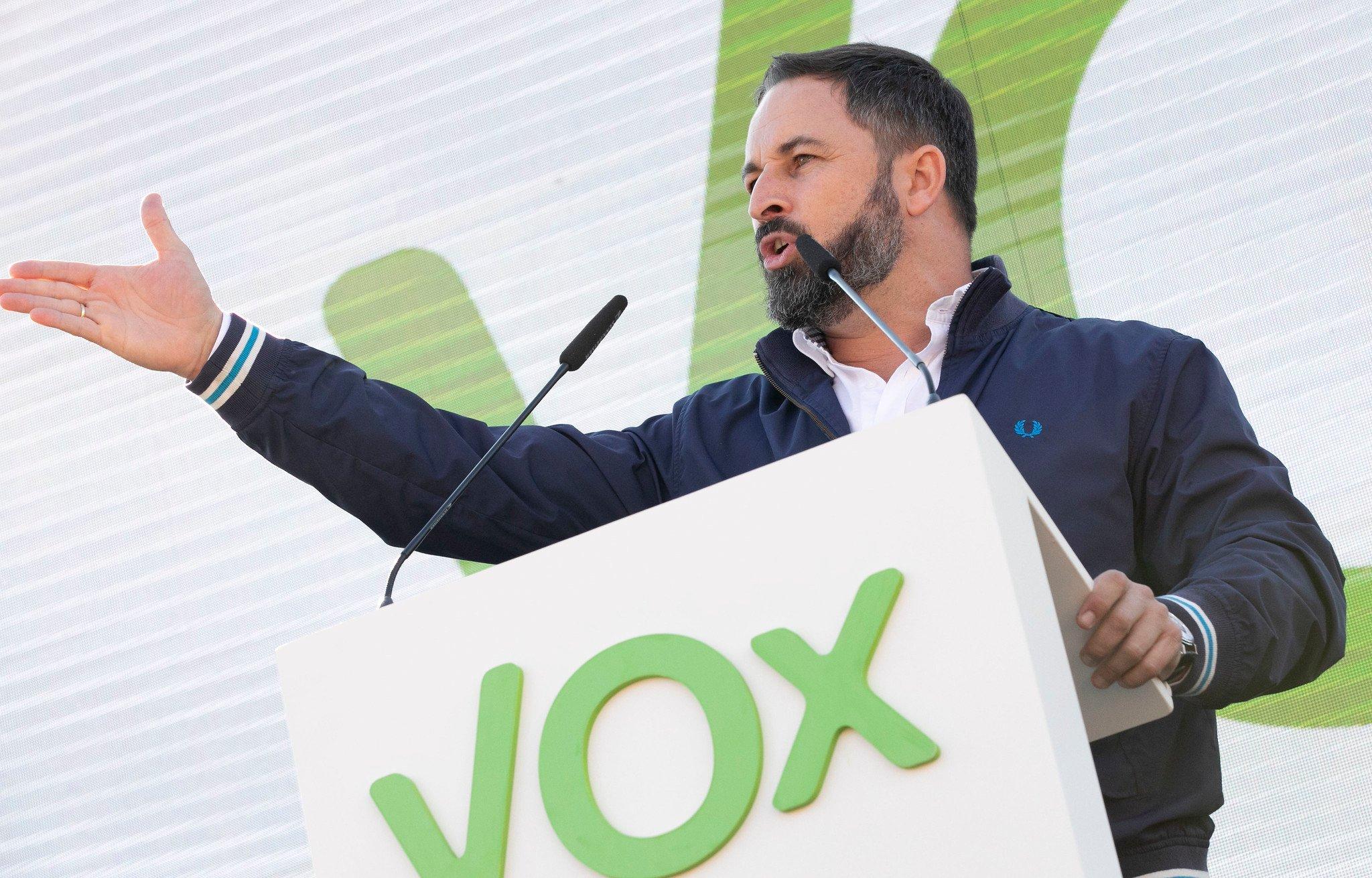Santiago Abascal przemawia z mównicy z logiem Vox