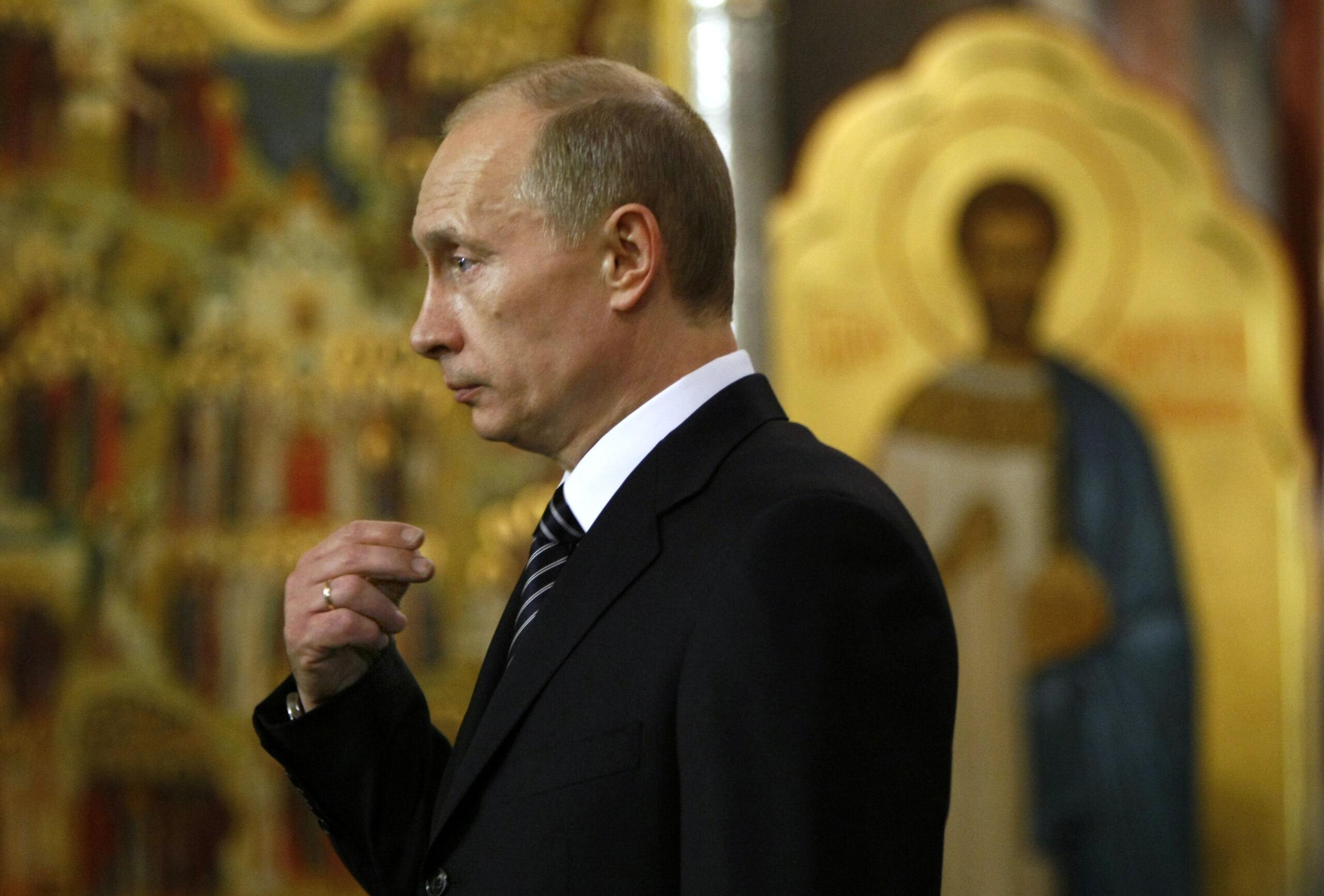 Władimir Putin żegna się na tle złotej ikony