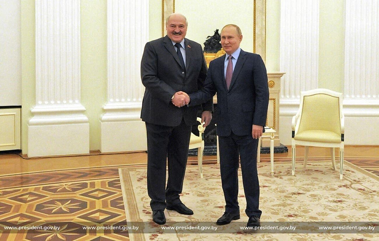 Dwa mężczyźni w starszym wieku ściskają sobie dłonie i uśmiechają się do zdjęcia, Łukaszenka i Putin