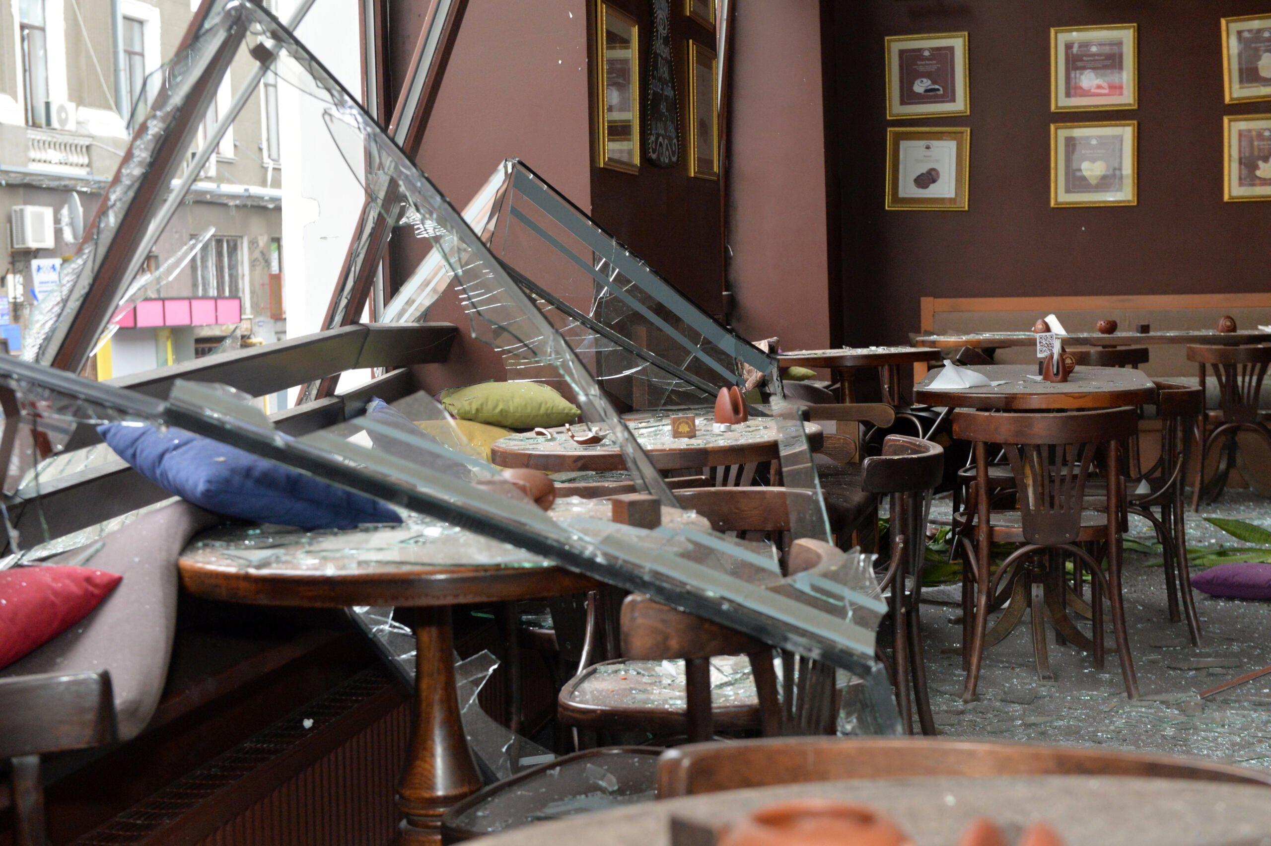 Zniszczona kawiarnia, okno z framugą wpadło do środka po ataku rakietowym w centrum Charkowa