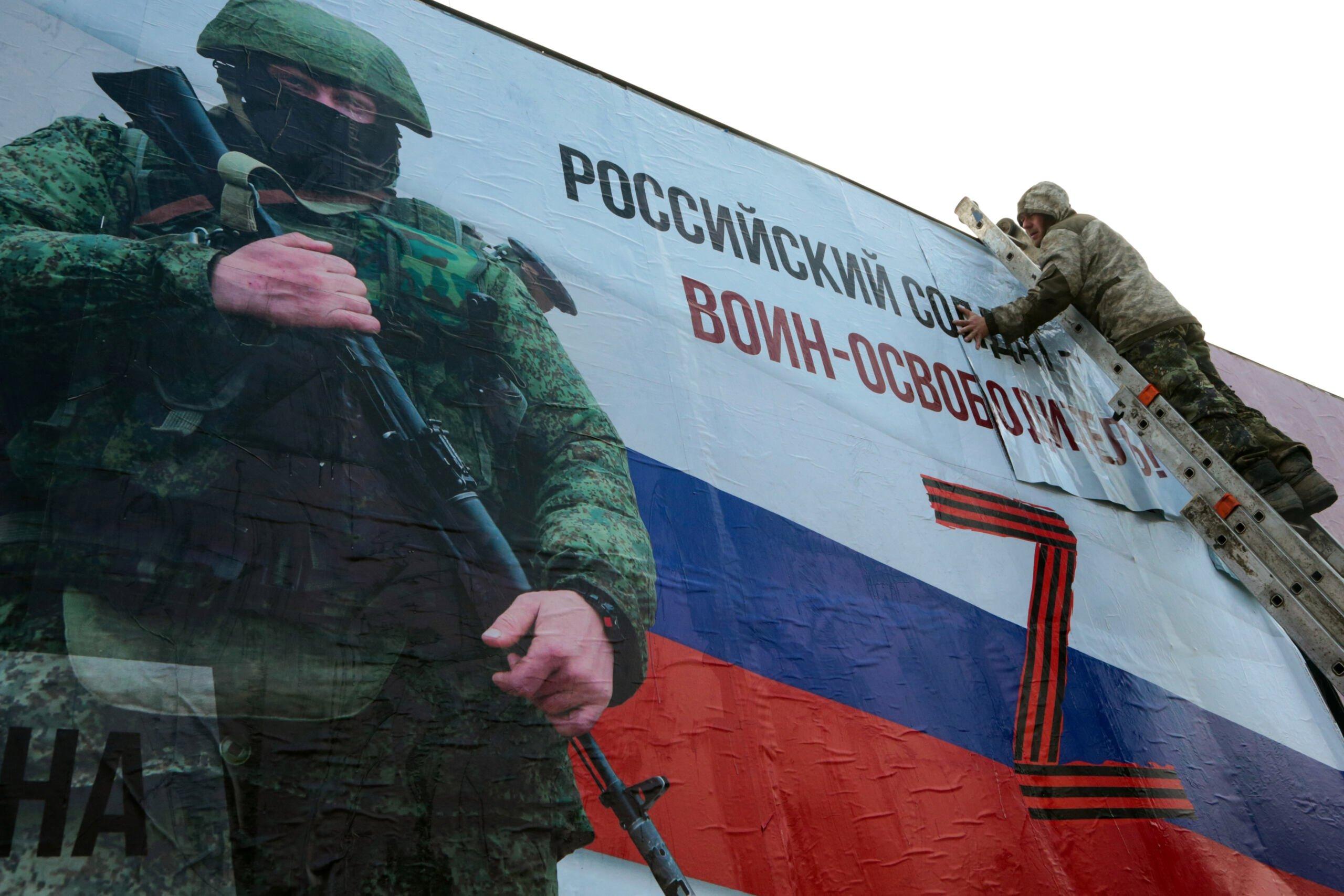 Plakat z stwetką uzbrojonego żołnierza i rosyjski napis "Rosyjski żołnierz to oswobodziciel"