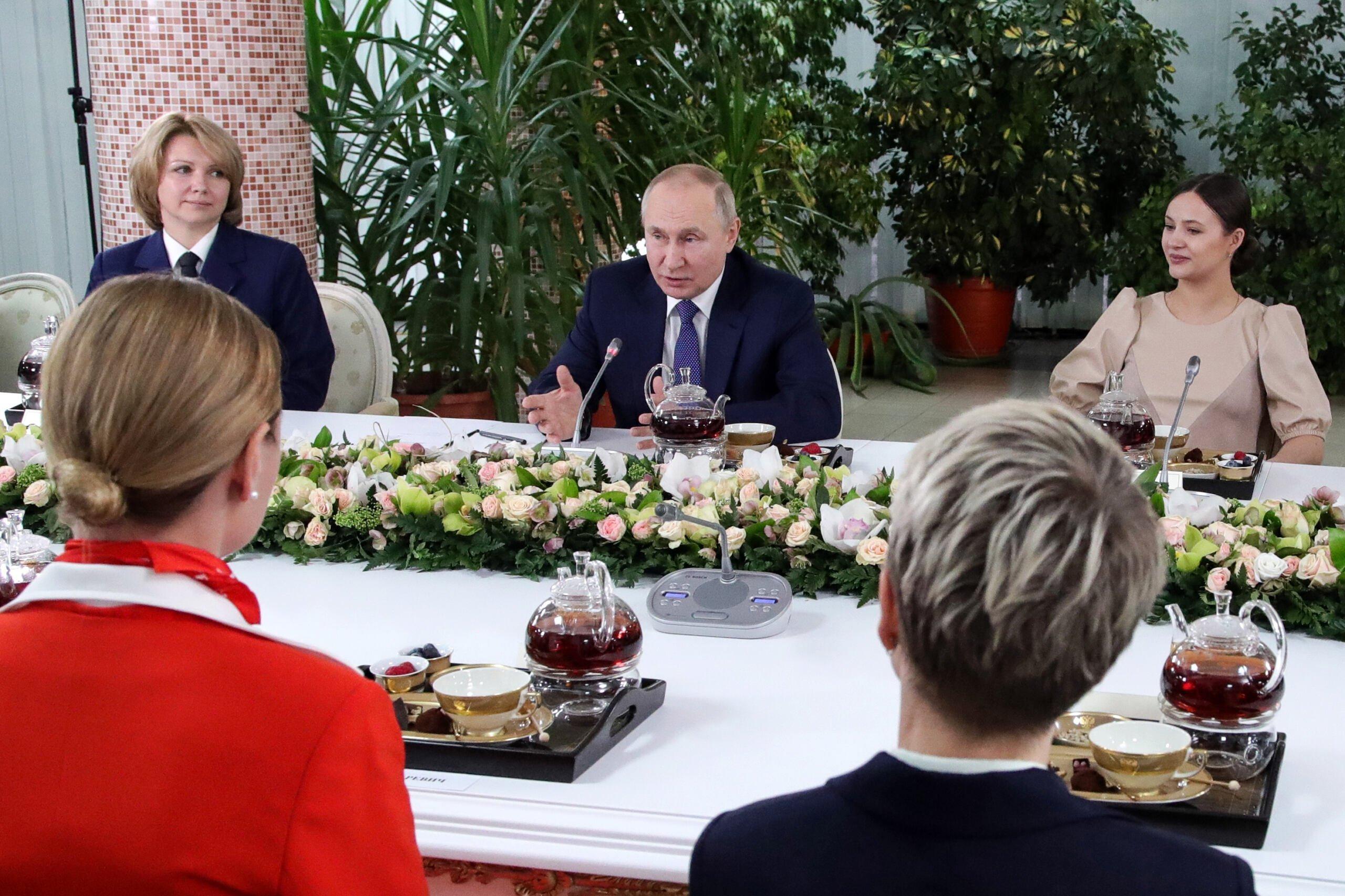Putin przy stole w otoczeniu kobiet
