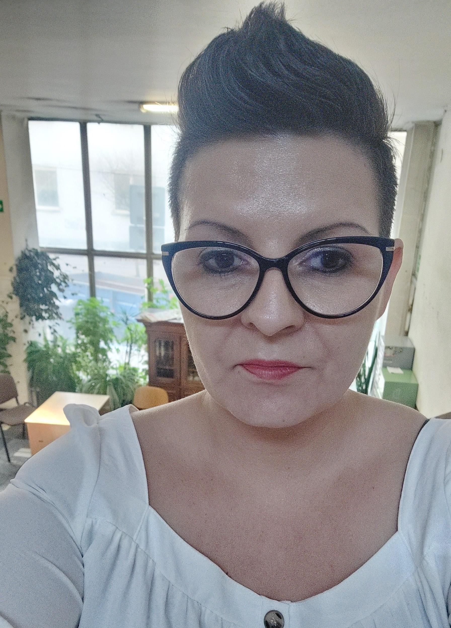 Kobieta z ciemnymi włosami w okularach w białej bluzce