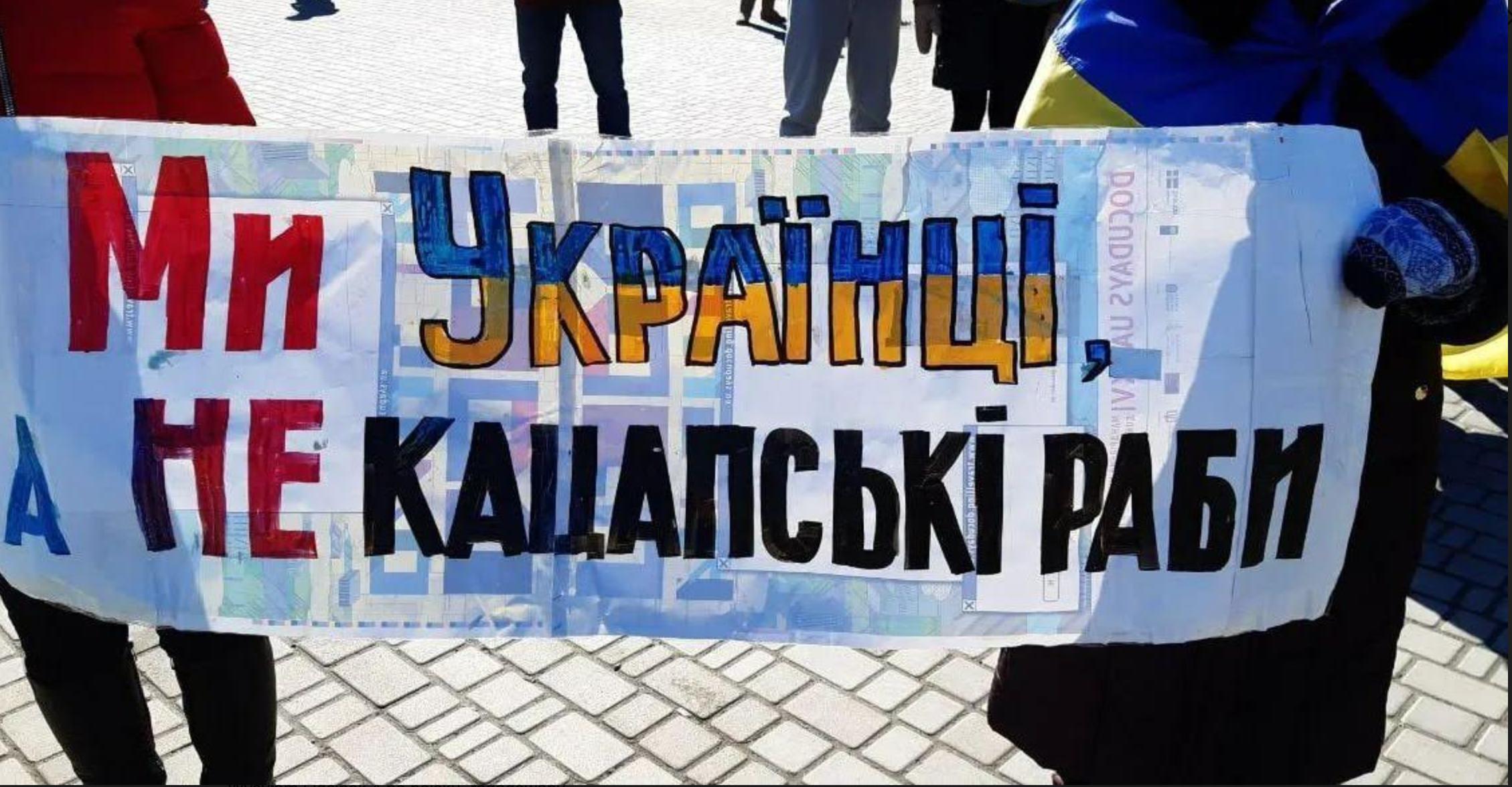 Transparent z napisem „Jesteśmy Ukraińcami, a nie kacapskimi niewolnikami" na manifestacji w Chersoniu