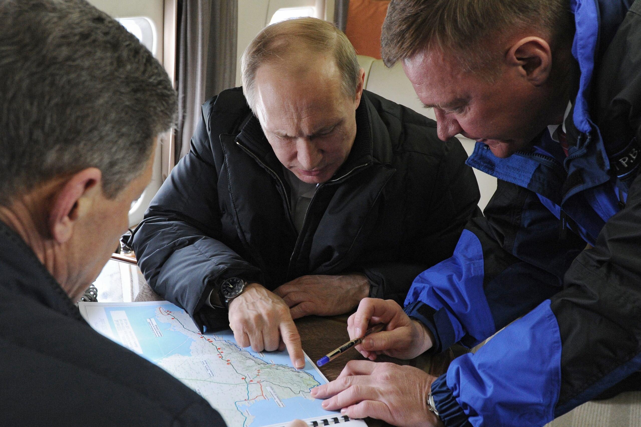 Putin pochyla się nad mapa Krymu