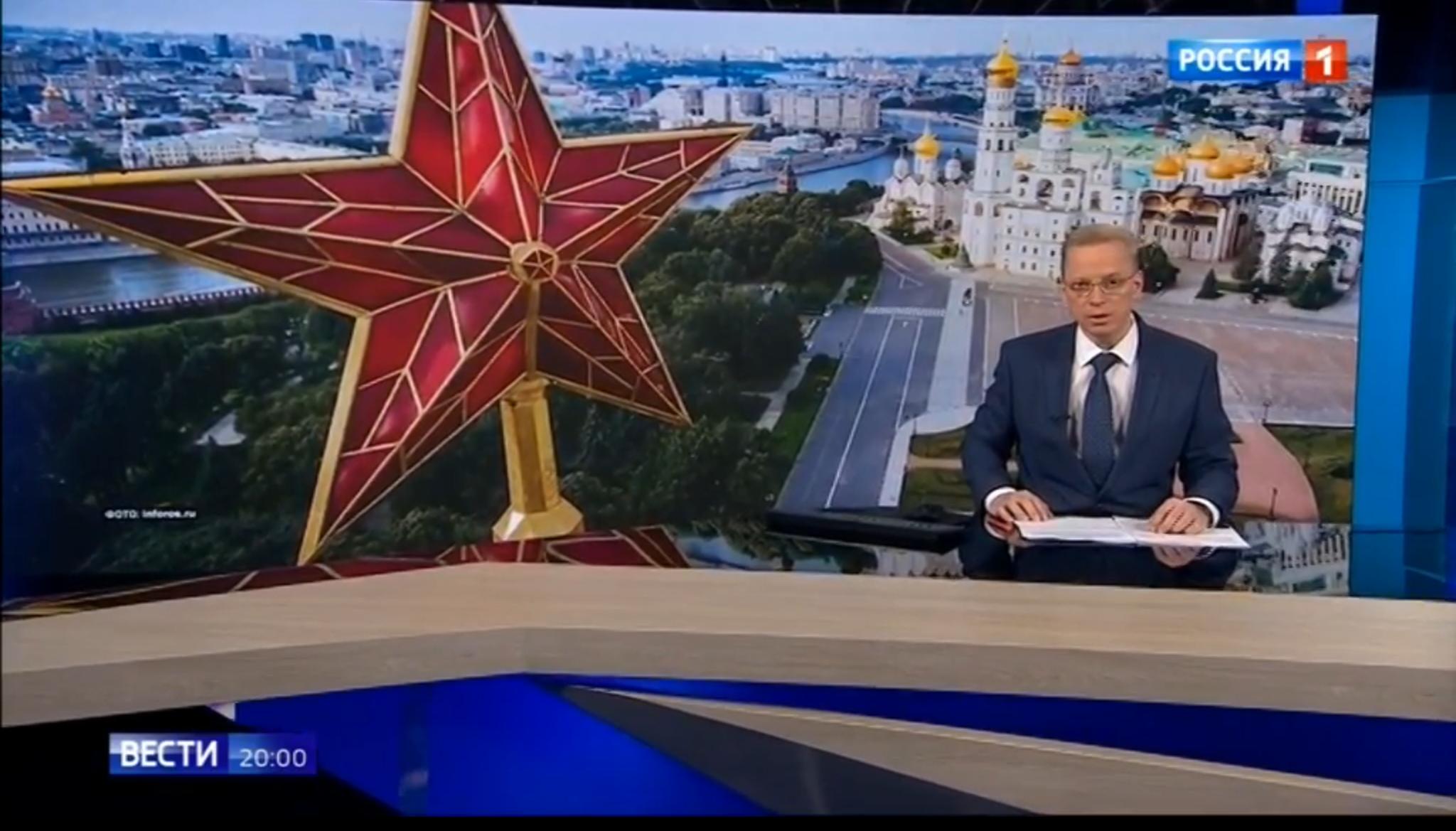 Studio telewizyjne z wielką czerwoną gwiazdą i cerkwią w tle. Rosyjski napis "Wiesti"