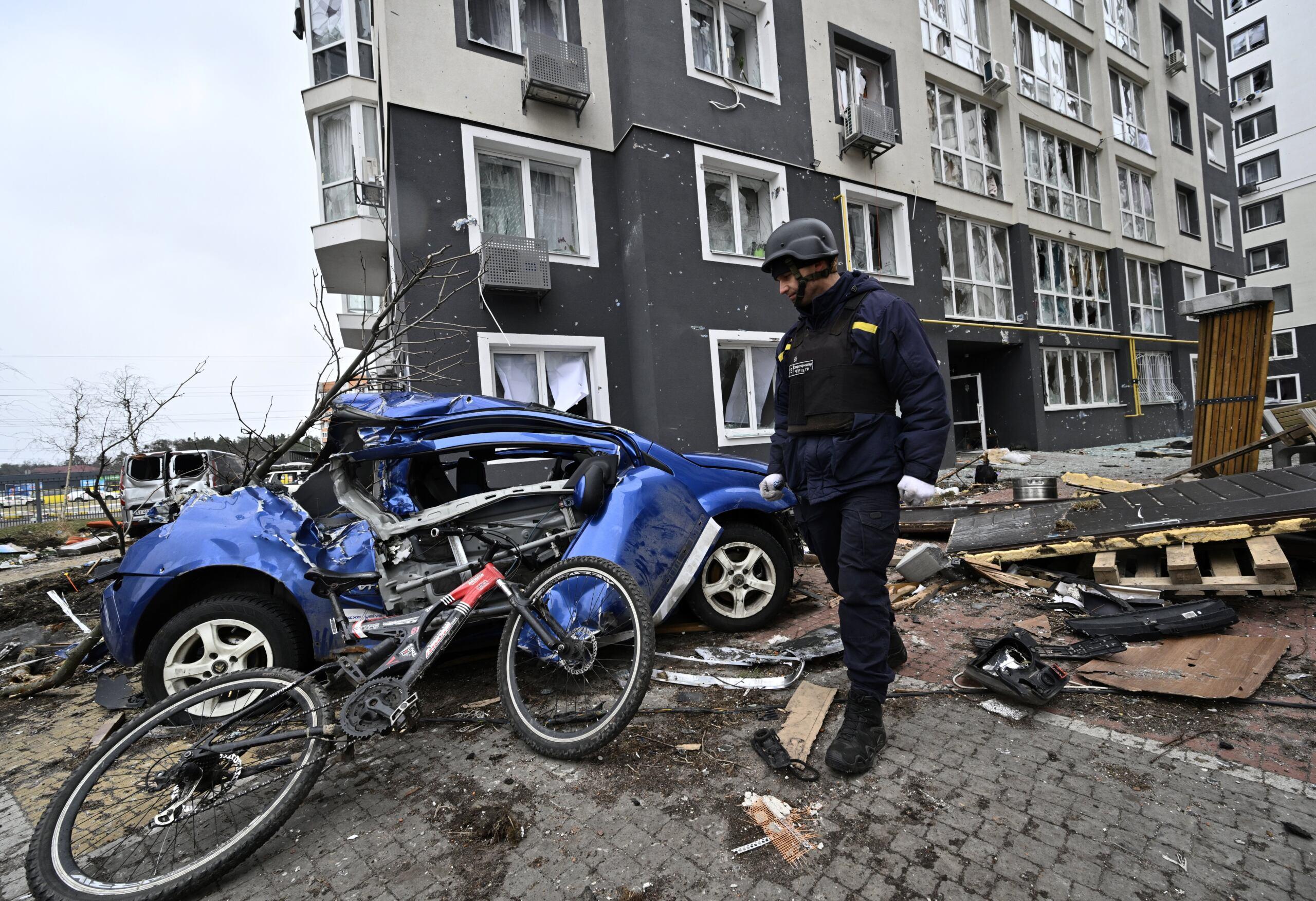 Ostrzelane osiedle mieszkalne w ukraińskiej Buczy: na zdjęciu zniszczony samochód i rower
