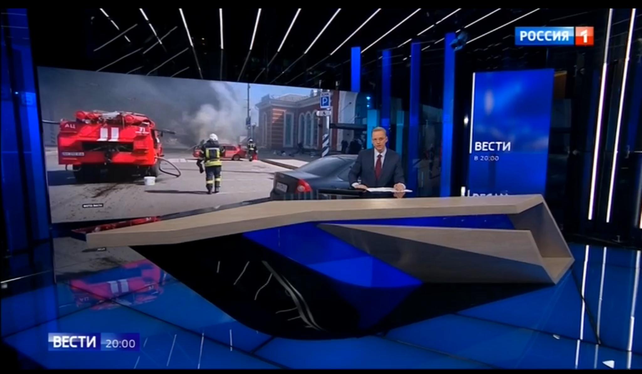 Studio telewizyjne, prowadzący, w tle zdjęcie miasta i wybuchu