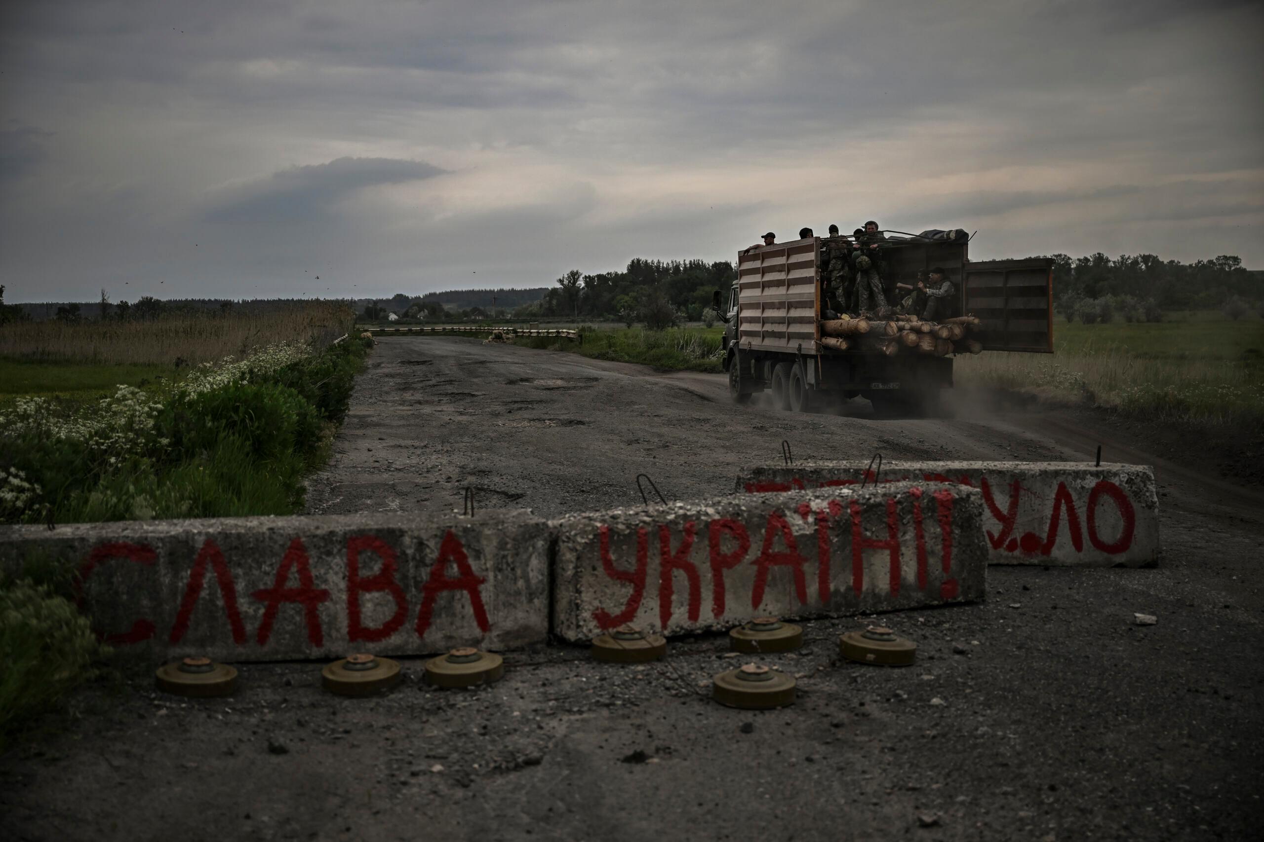 Droga z przerwaną betonową blokadą, na której napisano po ukrainsku "Sława Ukrainie"
