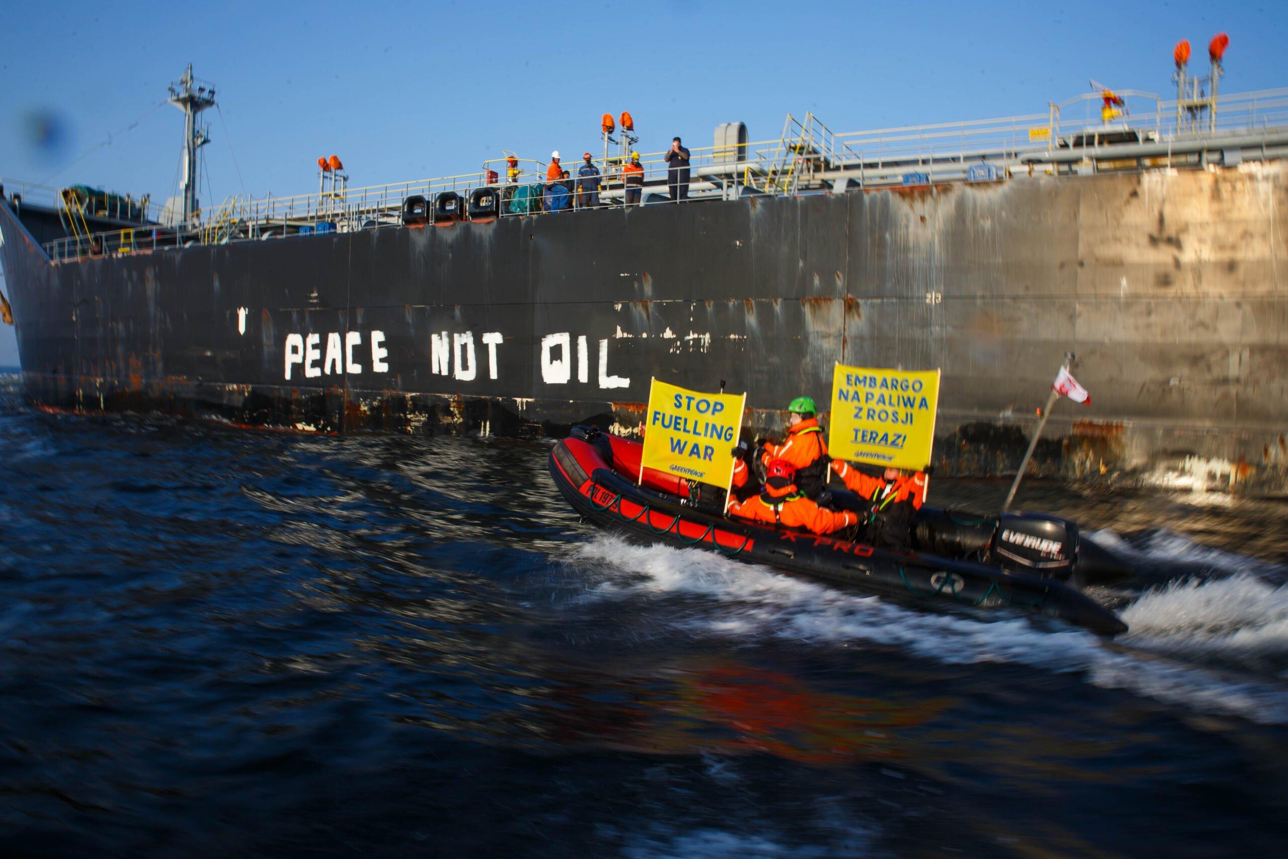 Duży ponton z ludźmi trzymającymi baner przeciw importowi ropy