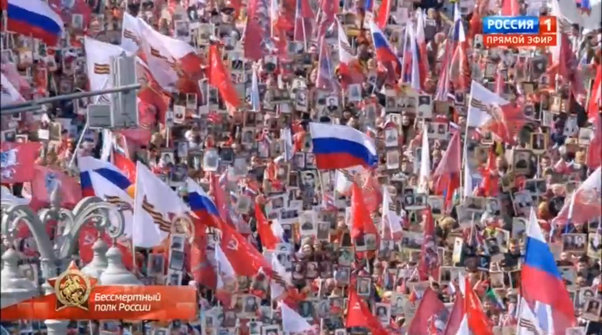 Tłum ludzi z flagami Rosji, ZSRR i portretami żołnierzy II wojny światpwej