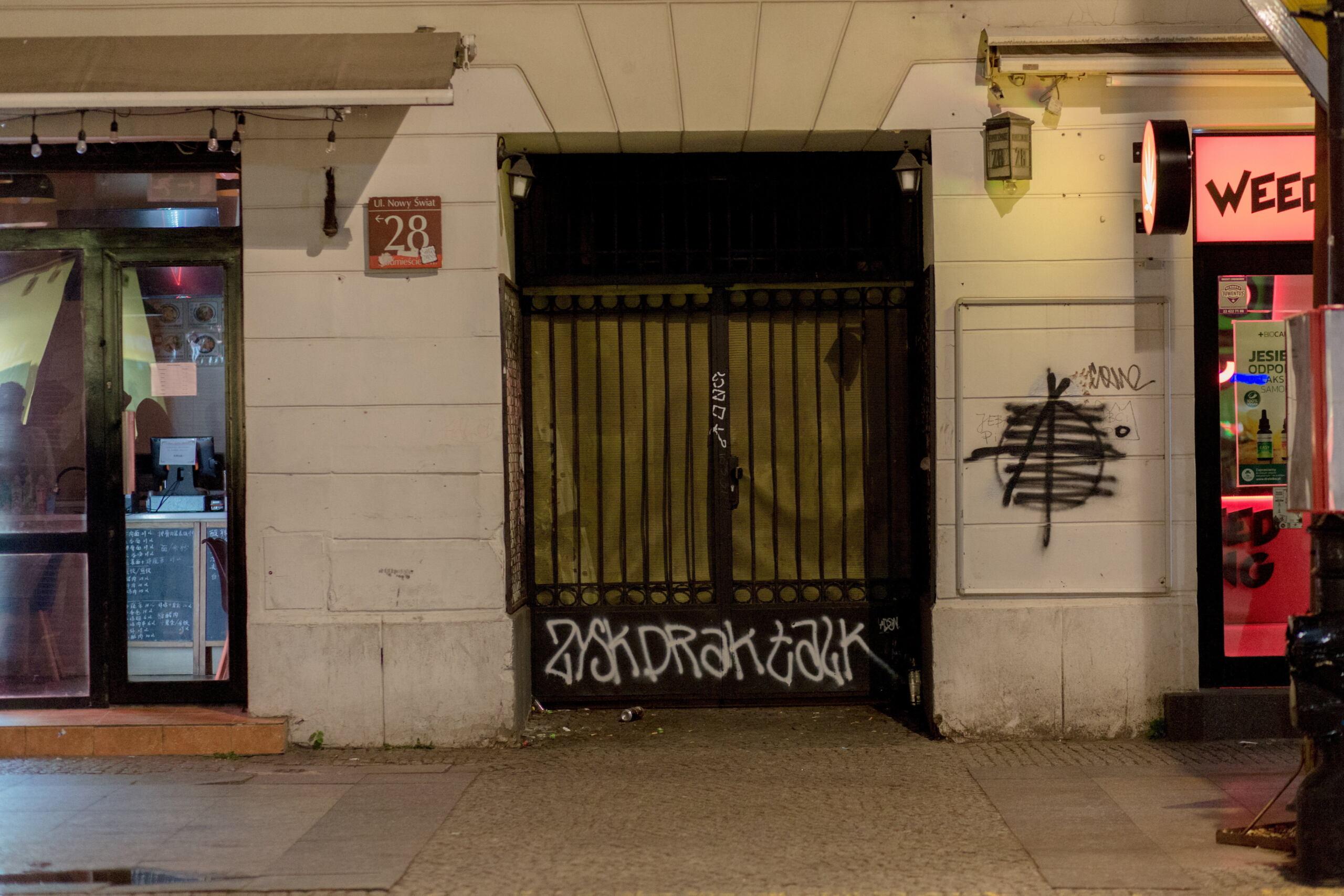 Brama na ul. Nowqy Świat, zamknieta, na murach grafitti