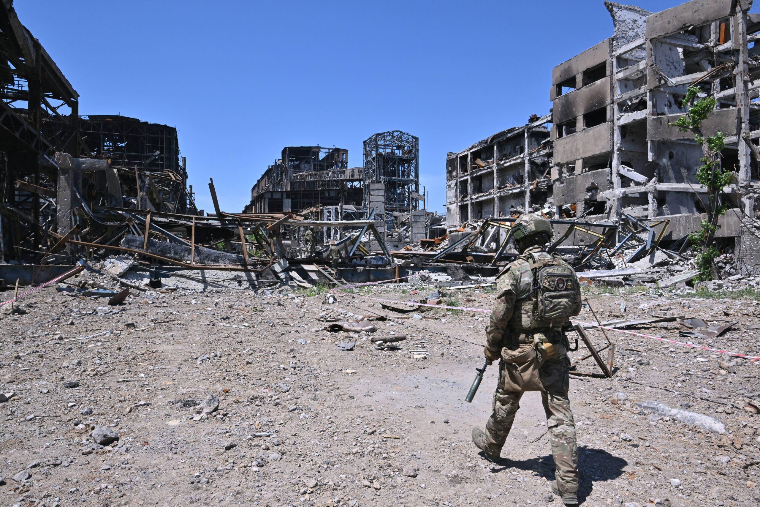 Rosyjski żołnierz patroluje teren wśród ruin budynków