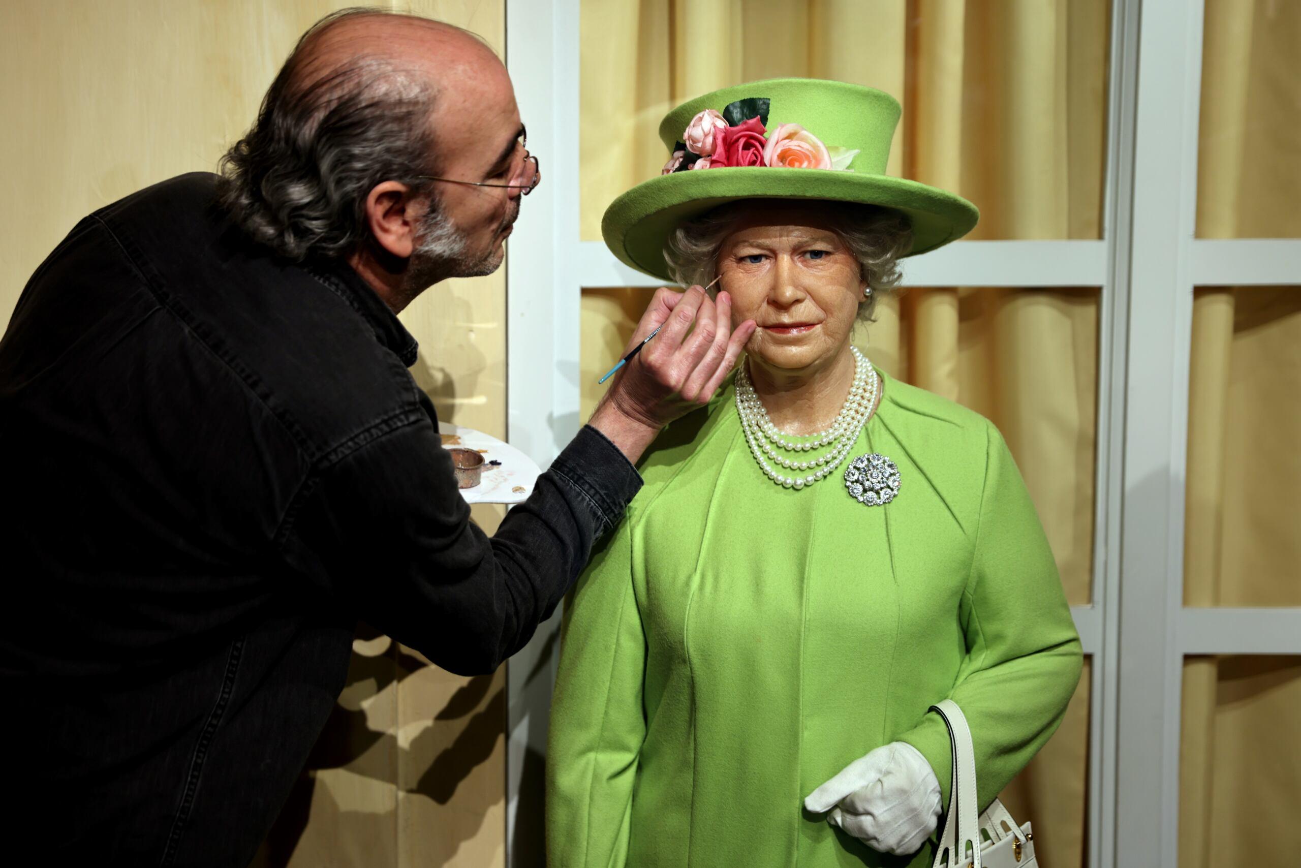 An artist renovate the wax statue of British Queen Elisabeth II at the Musee Grevin in Paris on June 2, 2022, as Britain celebrates the Queen's platinum jubilee. (Photo by Thomas COEX / AFP)