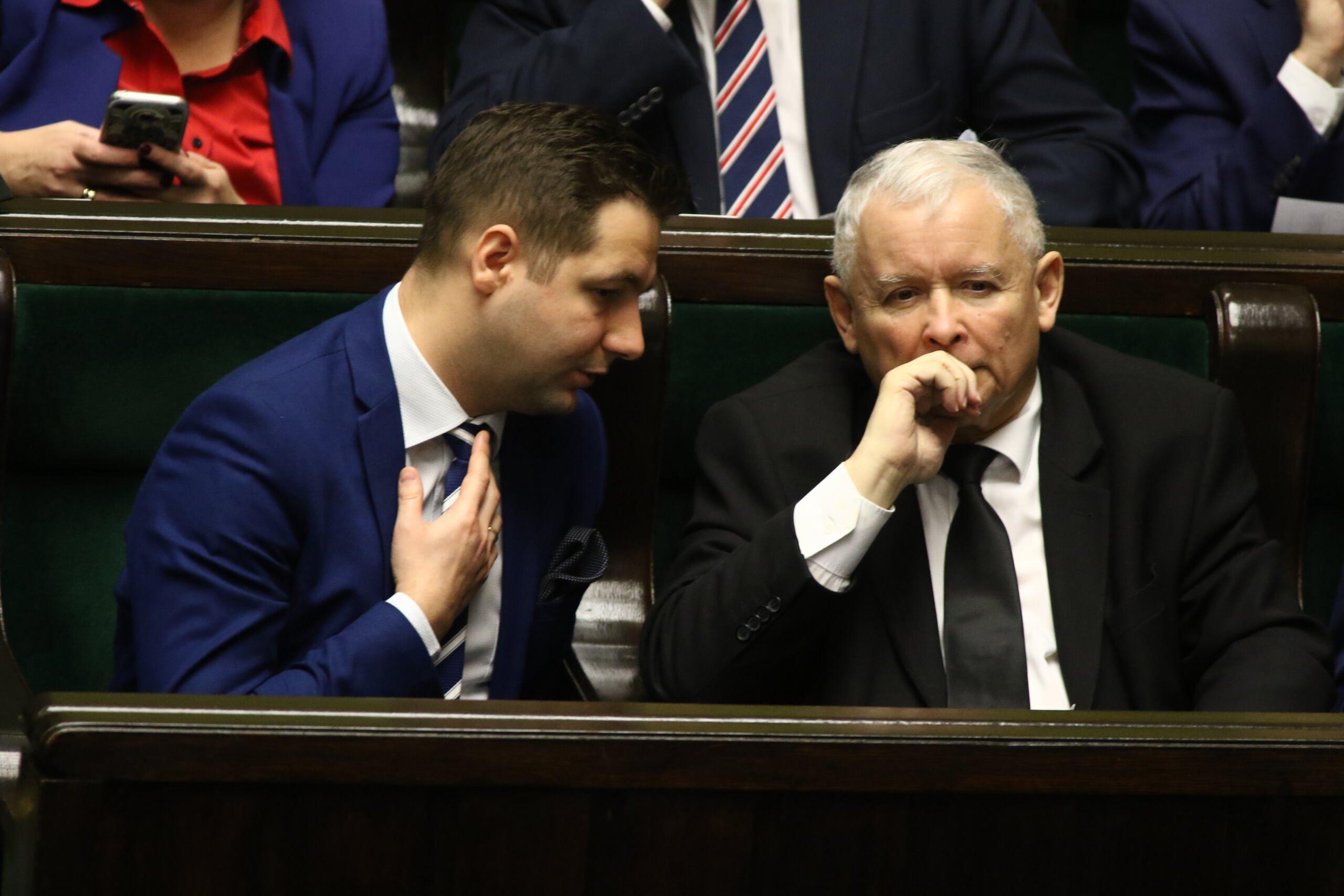 Patryki Jaki zwraca się w ławach sejmowych do siedzącego obok Jarosława Kaczyński, Kaczyński patrzy w dal