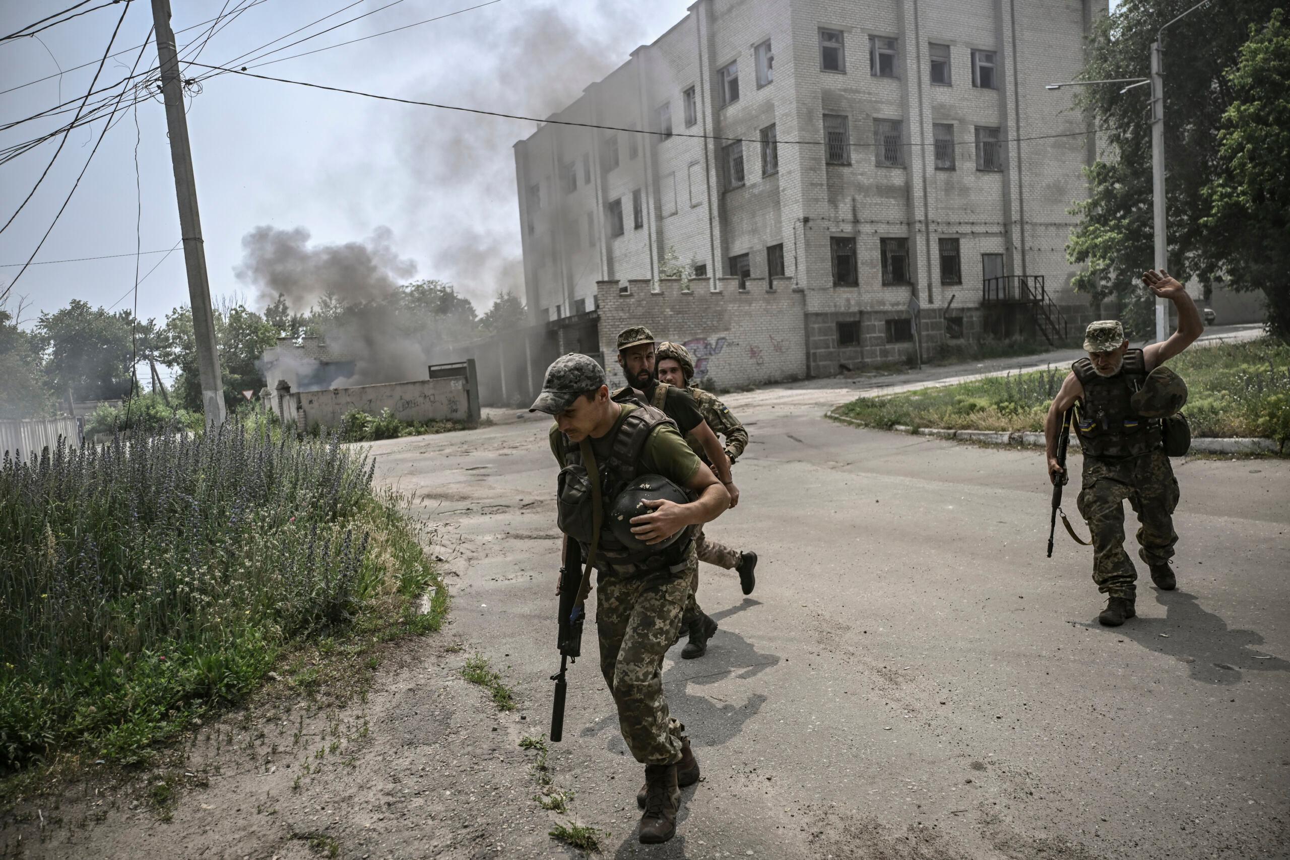 Ukraińscy żołnierze uciekają w poszukiwaniu osłony podczas pojedynku artyleryjskiego między ukraińskimi i rosyjskimi wojskami w mieście Łysyczańsk, wschodnioukraiński region Donbas, 11 czerwca 2022 r.