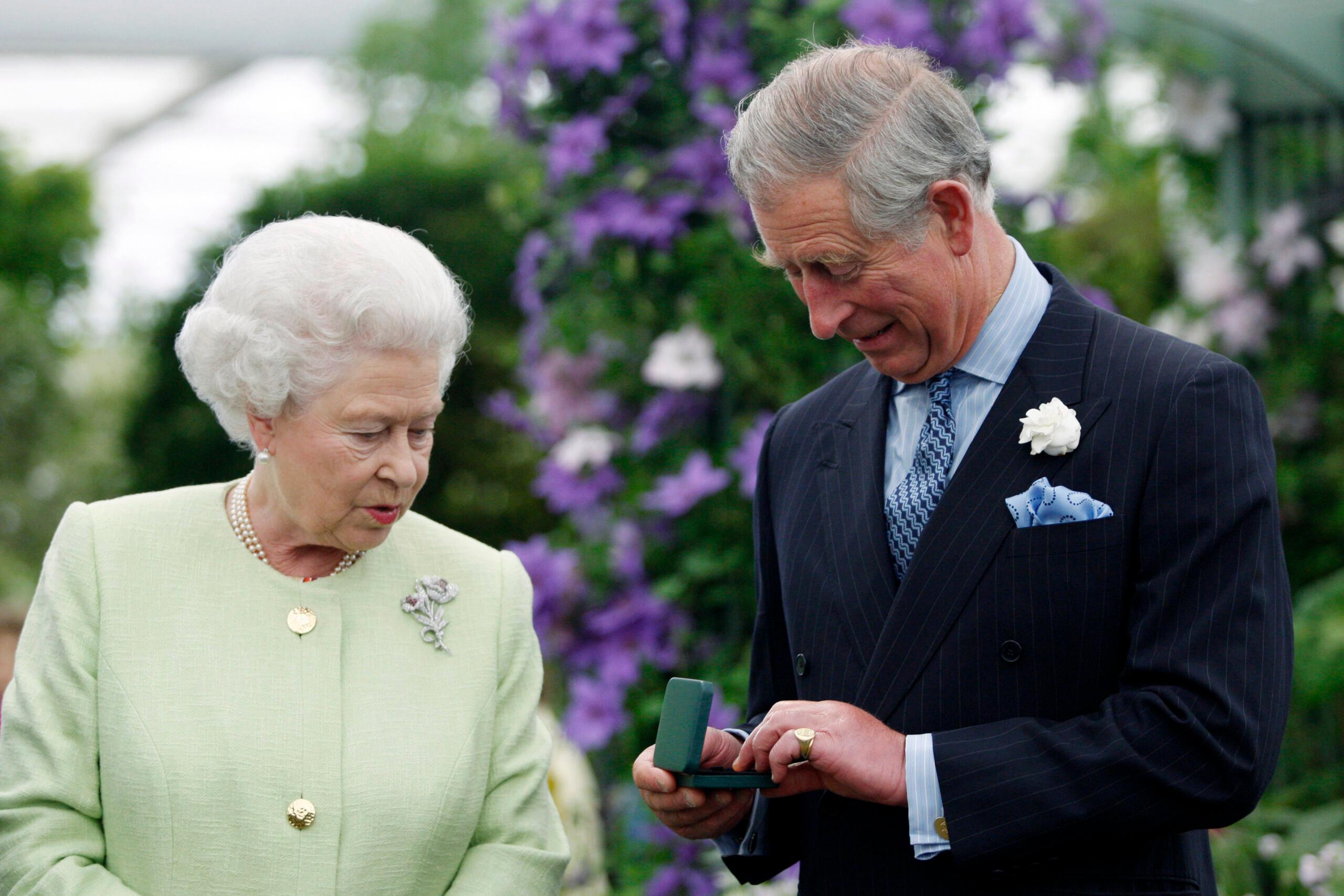 Britain Queen Elizabeth II presents to Prince Charles with a Royal Horticultural Society's Victoria Medal of Honour during a visit to Chelsea Flower Show in London, on May 18, 2009. The Victoria Medal of Honour is the highest accolade that the Royal Horticultural Society can bestow.    AFP    PHOTO  ROTA  POOL/SANG TAN (Photo by SANG TAN / POOL / AFP)
