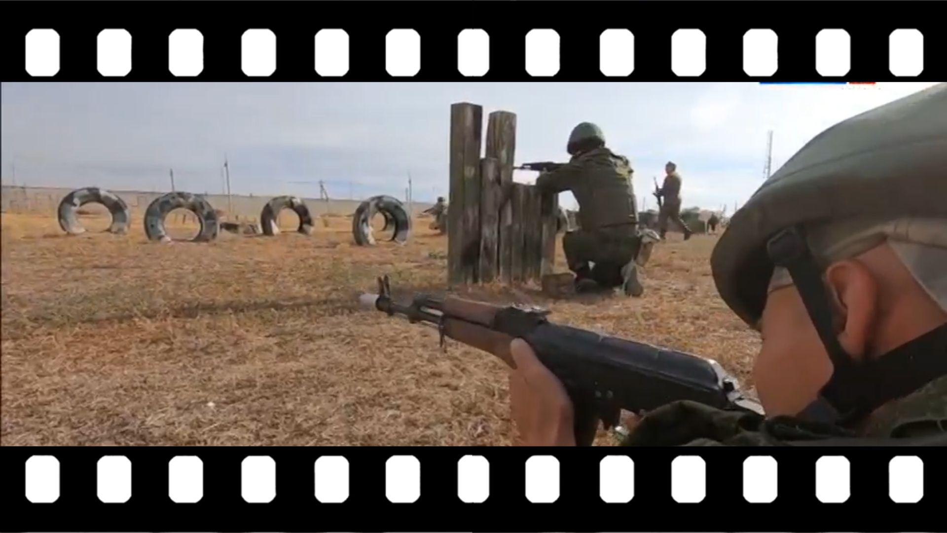 Grafika: klatka filmowa ze zdjęciem żołnierzy na poligonie