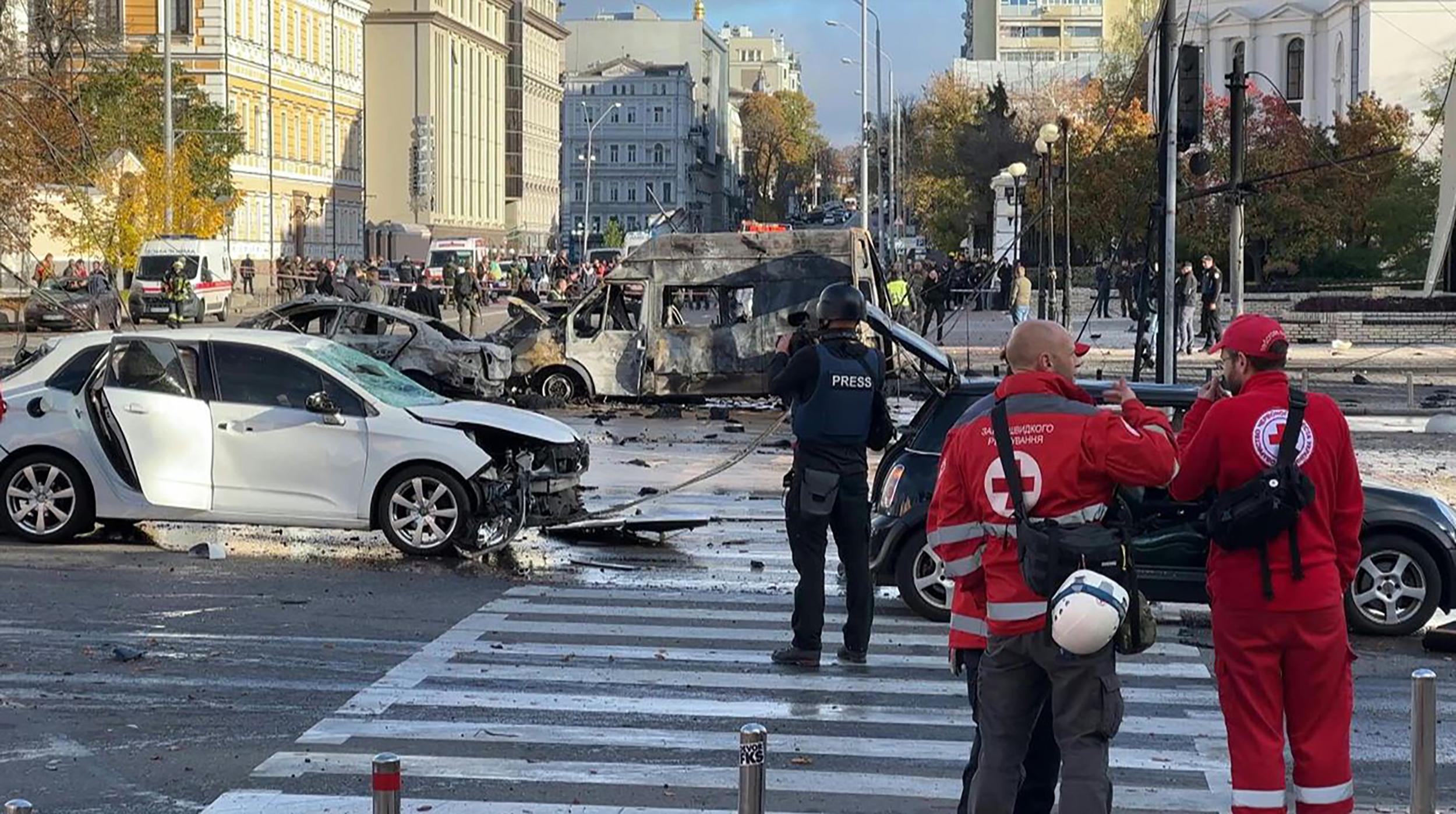 This video grab taken from an AFPTV footage shows vehicles destroyed in Kyiv on October 10, 2022 as security and emergency forces work on the scene after several missile strikes were heard in the Ukrainian capital. (Photo by Arman SOLDIN / AFPTV / AFP)