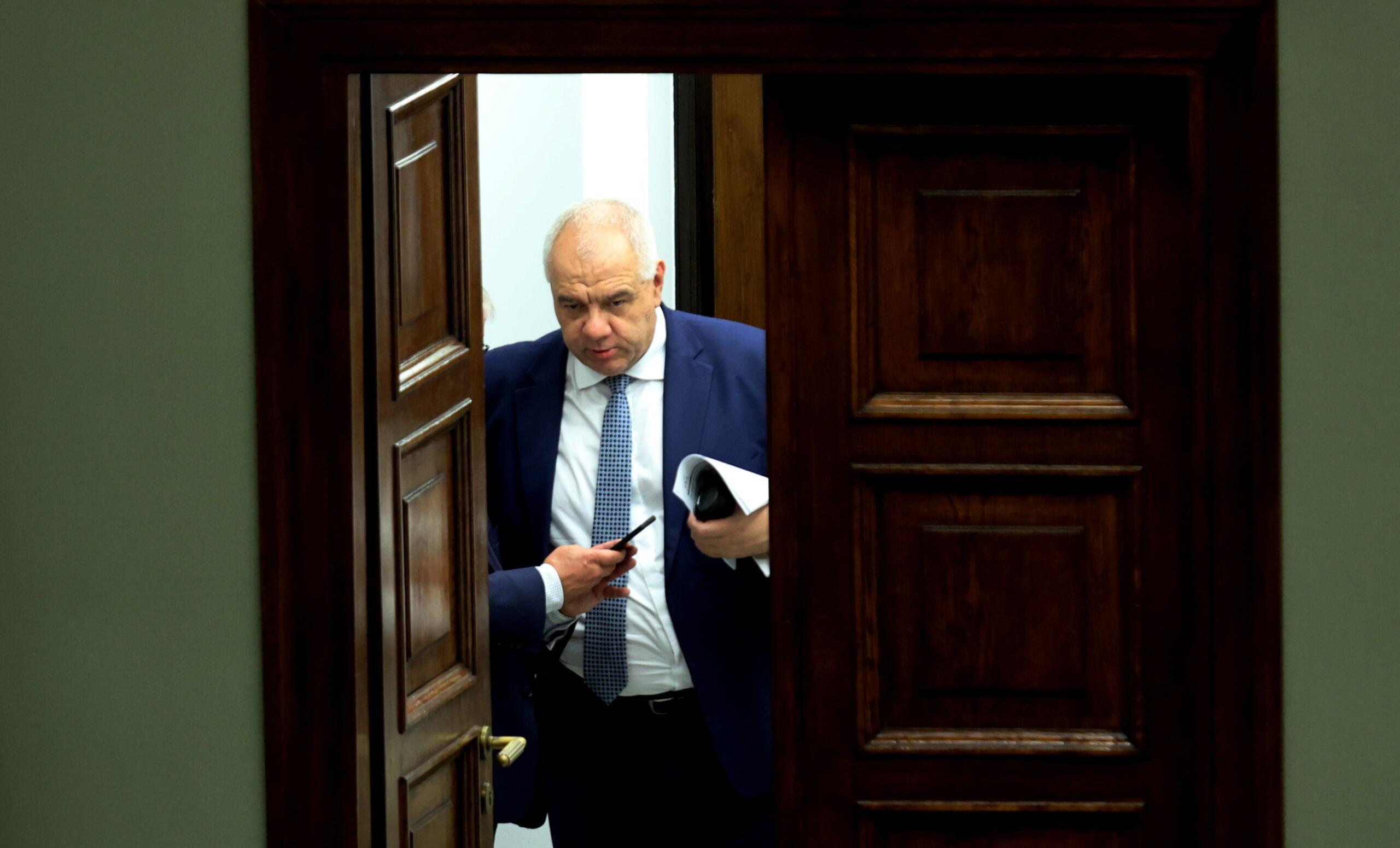 Minister Jacek Sasin stoi w drzwiach, w przejściu prowadzącym z sejmowych kuluarów do ław rządowych