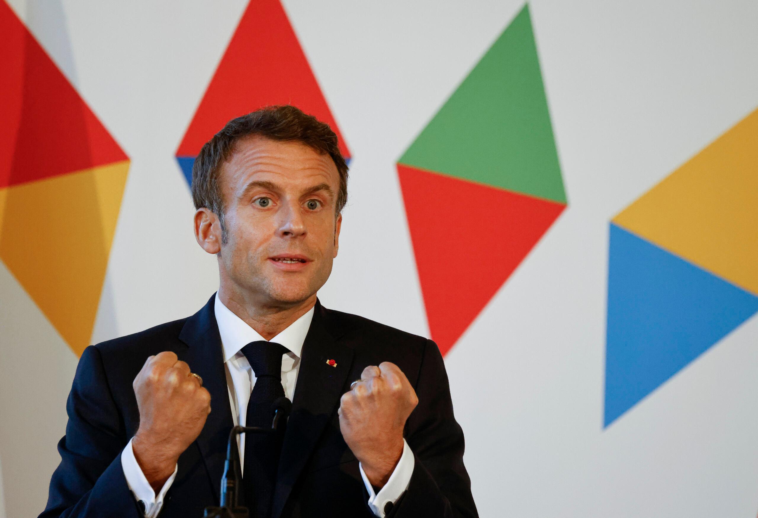 Mężczyzna w ferworze przemawiania podnoso zaciśniete ręce, Emmanuel Macron