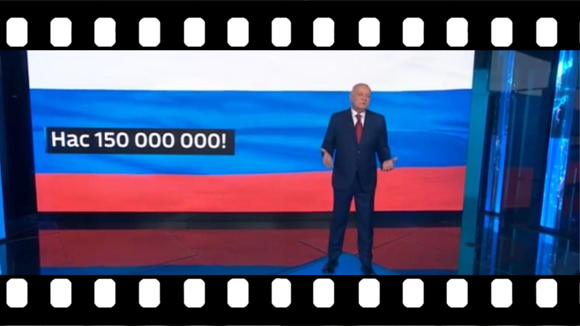 Męzczyzna w studio na tle rosyjskiego napisu "Jest nas 150 milionów"