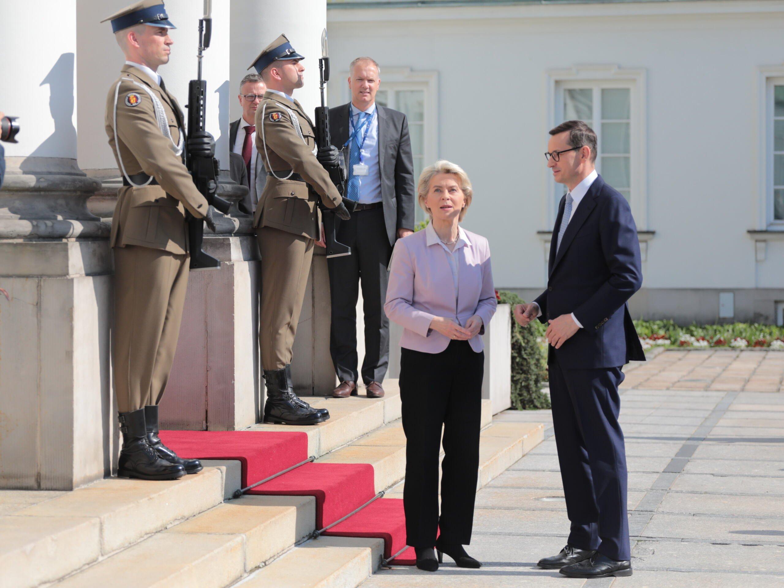 Ursula von der Leyen stoi przed Belwederem w towarzystwie Mateusza Morawieckiego, za nimi dwóch żołnierzy