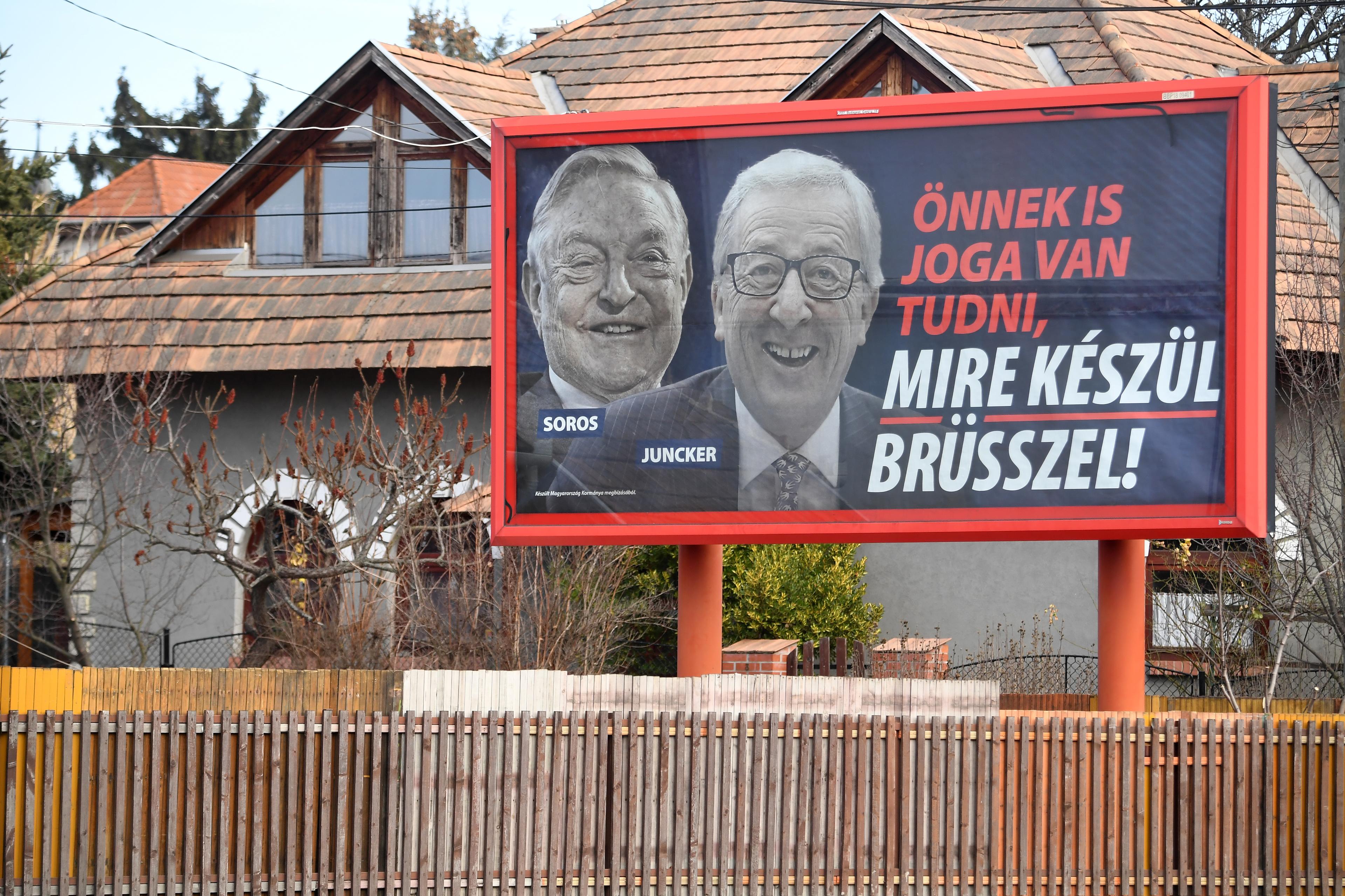 A picture taken on February 26, 2019 in Budapest shows a billboard bearing portraits of European Commission chief Jean-Claude Juncker (R) and Hungarian-born US investor and philanthropist George Soros and a slogan reading "You too have a right to know what Brussels is preparing". - Opposition activists in Hungary on February 25, 2019 defaced hundreds of posters put up by the government of nationalist Prime Minister Viktor Orban attacking European Commission chief Jean-Claude Juncker and billionaire George Soros. (Photo by ATTILA KISBENEDEK / AFP)