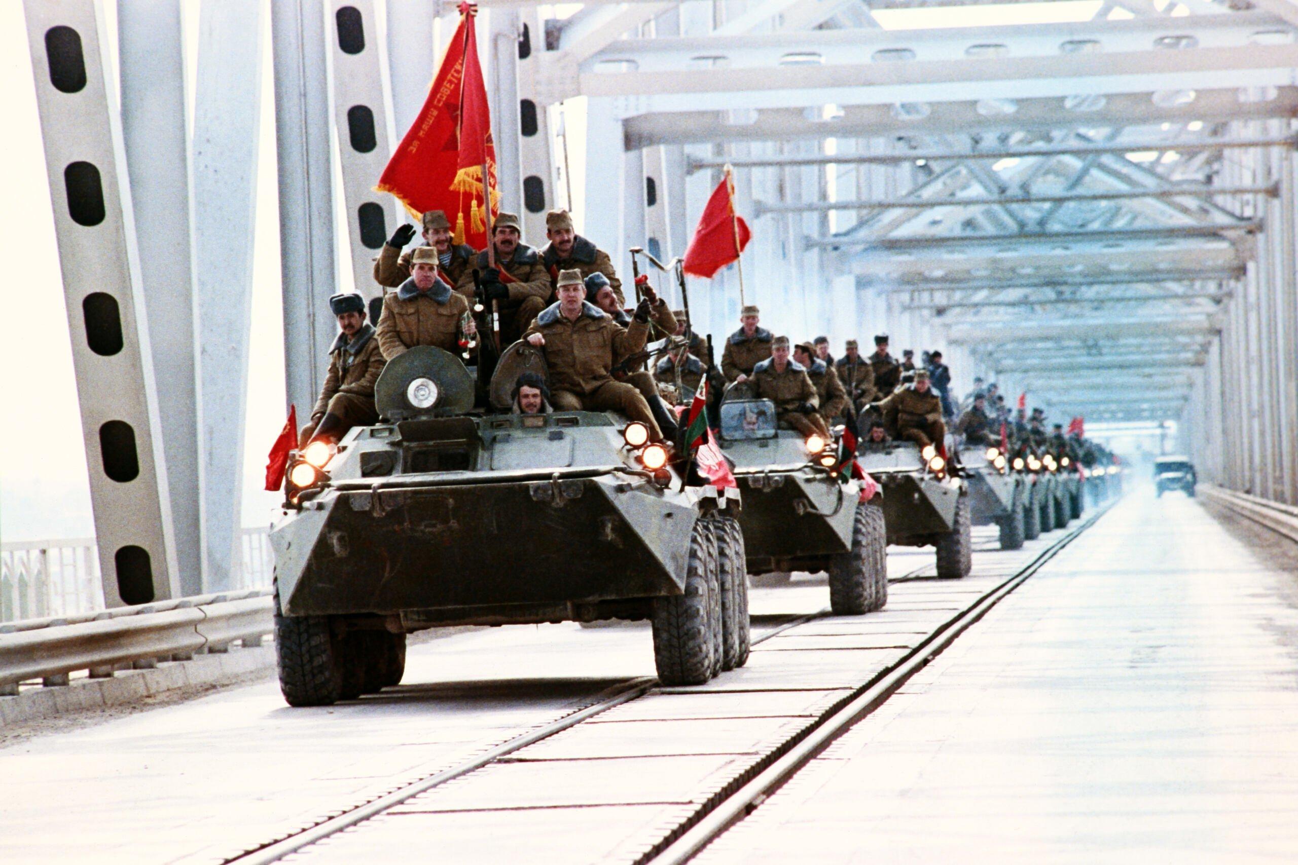 transportery wojskowe z żołnierzami jadą przez most