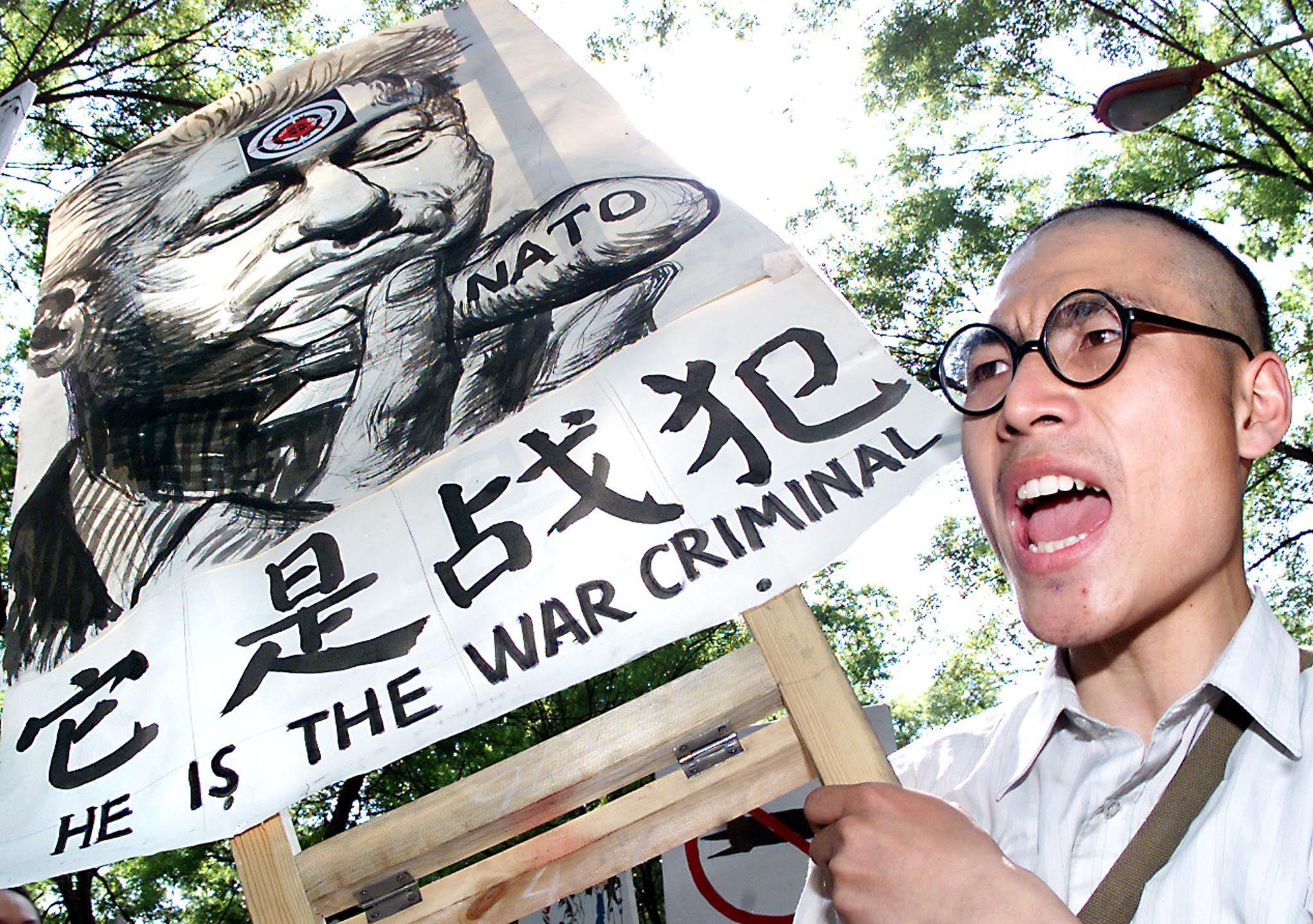 A student yells "kill Clinton" as he carries a giant caricature of the US President10 May 1999 in Beijing as hundreds of demonstrators march to the US embassy in the third day of protests after the NATO bombing of the Chinese embassy in Belgrade.  Ignoring expression of regret from US President Bill Clinton and other NATO leaders, up to 100,000 demonstrators flooded the streets surrounding the US embassy in Beijing in the biggest protest seen in the capital since the 1989 pro-democracy movement.  US ambassador to China James Sassar said that personnel at his embassy had been "hostages" for the last 48 hours.      (ELECTRONIC IMAGE)       AFP PHOTO/Stephen SHAVER (Photo by STEPHEN SHAVER / AFP)